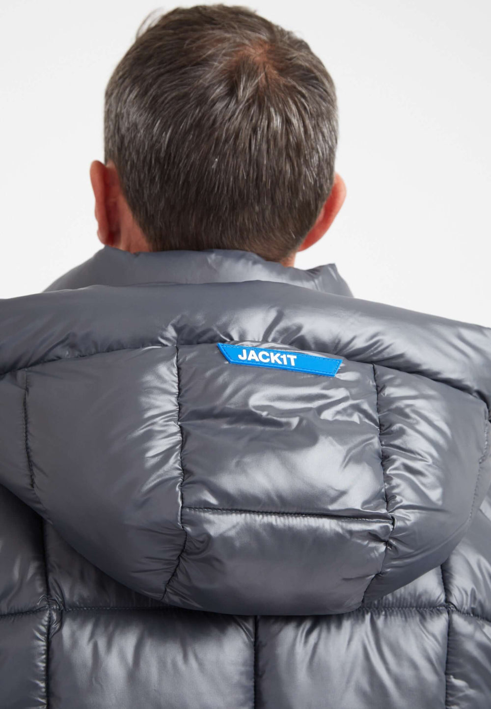 Back view of a man wearing the EZ Boxed Puffer Racer Lux Jacket in graphite black, featuring a grown-on hood and premium insulation. Mens grey racer jacket.