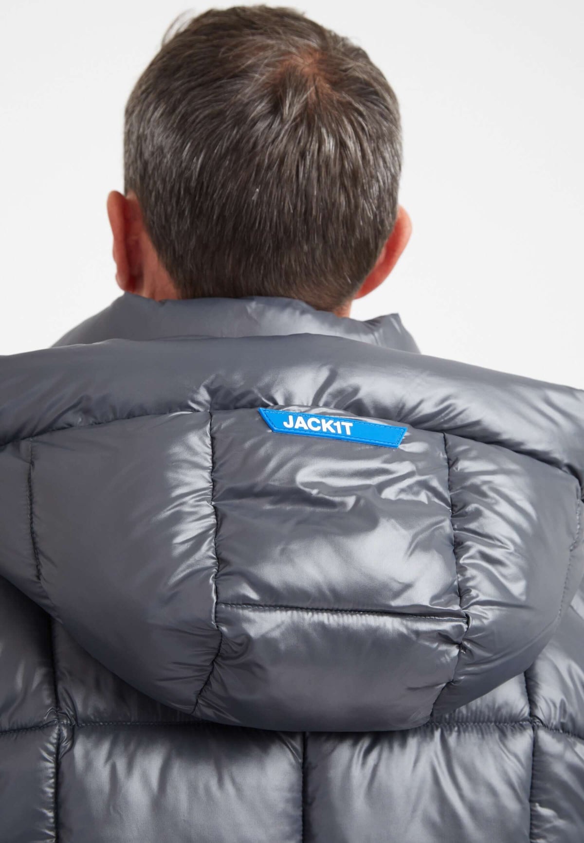 Back view of a man wearing the EZ Boxed Puffer Racer Lux Jacket in graphite black, featuring a grown-on hood and premium insulation. Mens grey racer jacket.