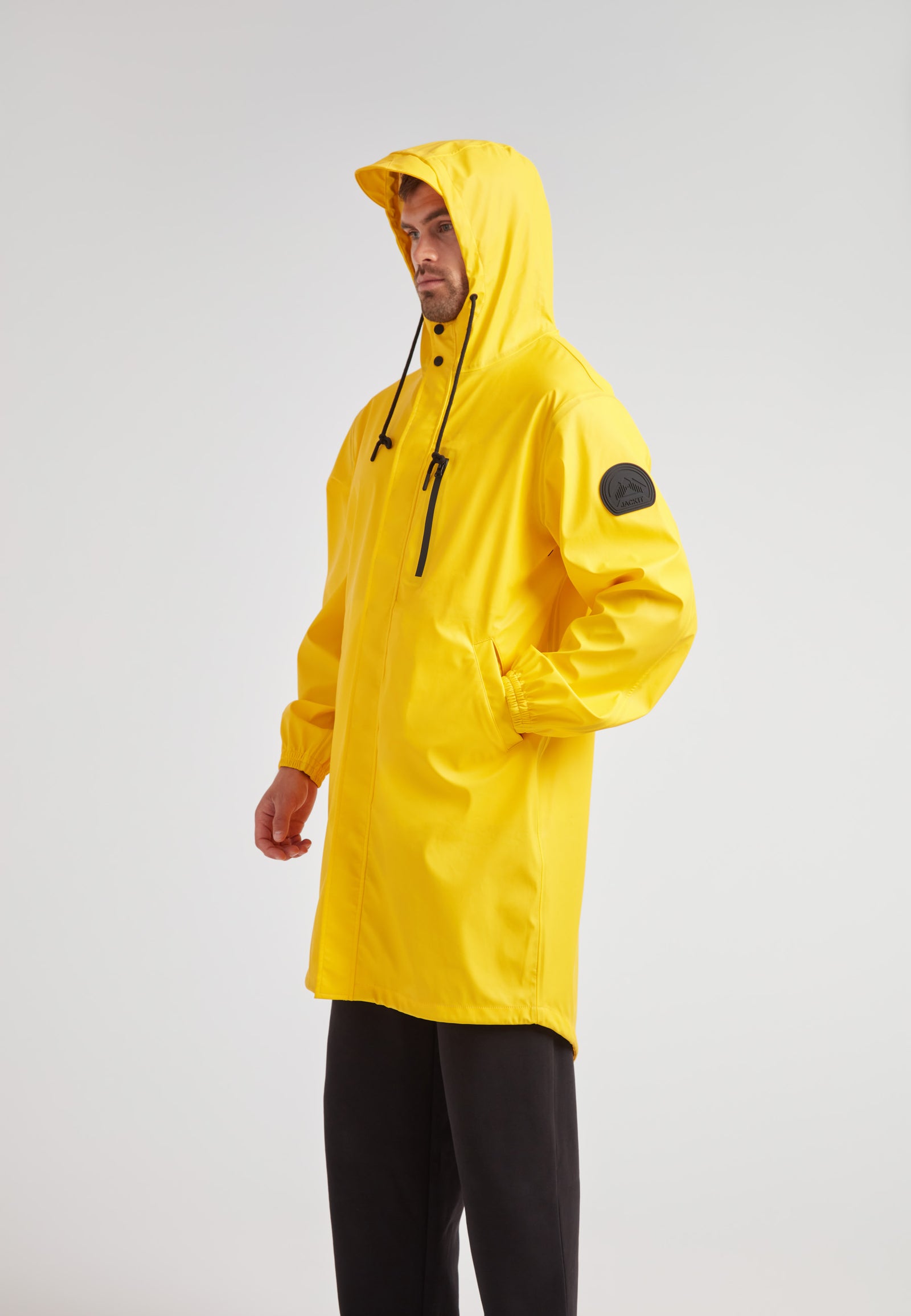 Yellow unisex long raincoat worn by a model, showcasing the lightweight design and hood.