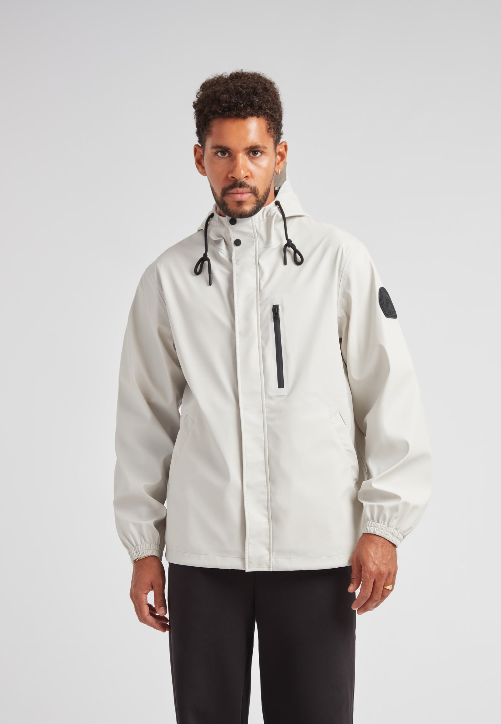 MODEL WEARING ELEMENTS Unisex Raincoat 2.0 Stone, showcasing a stylish and functional design in a neutral color.