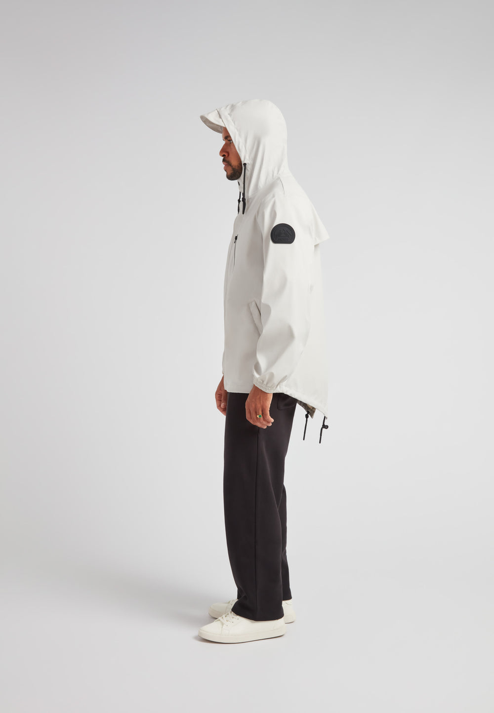 ELEMENTS Unisex Raincoat 2.0 Stone shown in a stylish side view, featuring a hood and adjustable fit.