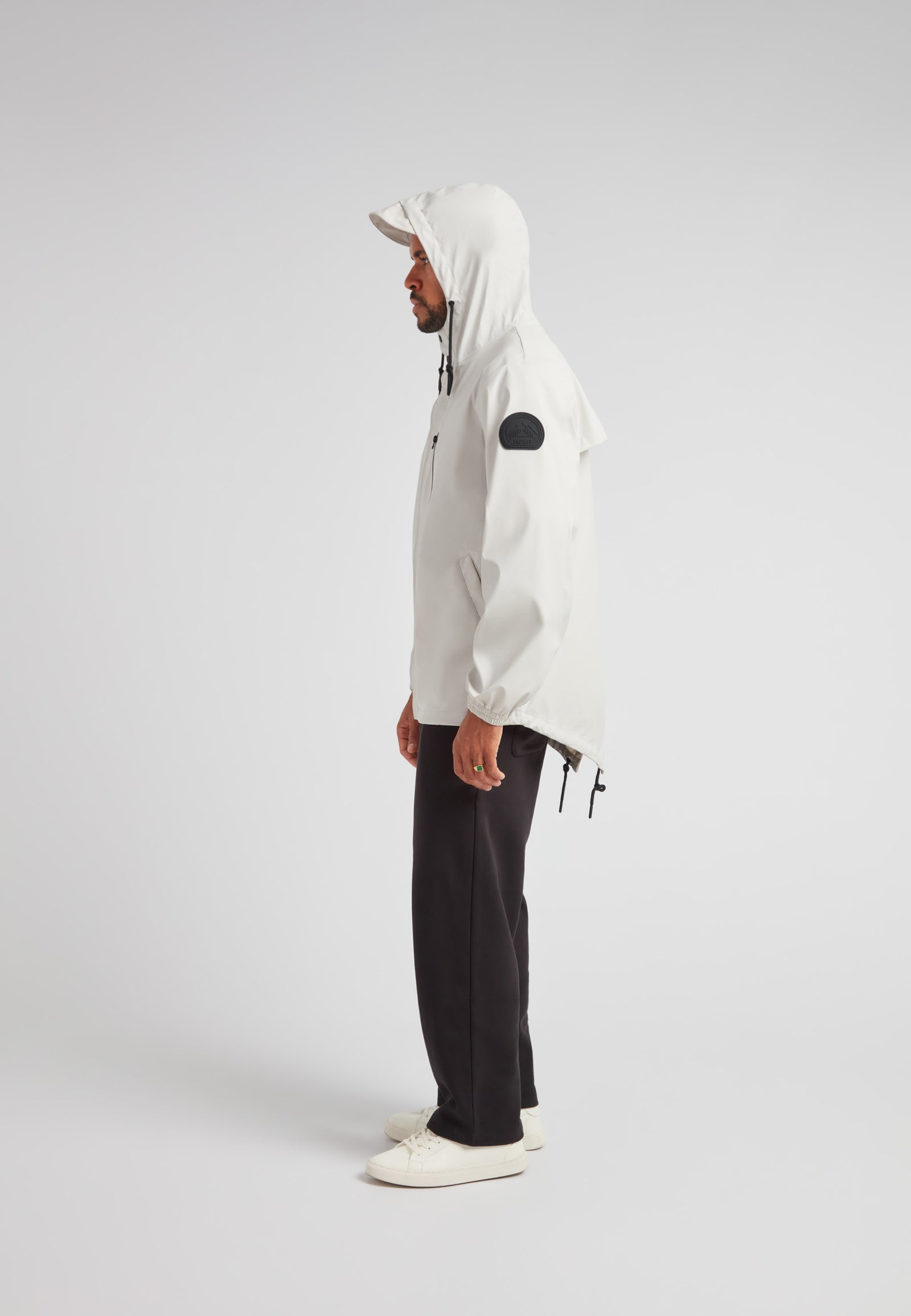 ELEMENTS Unisex Raincoat 2.0 Stone shown in a stylish side view, featuring a hood and adjustable fit.