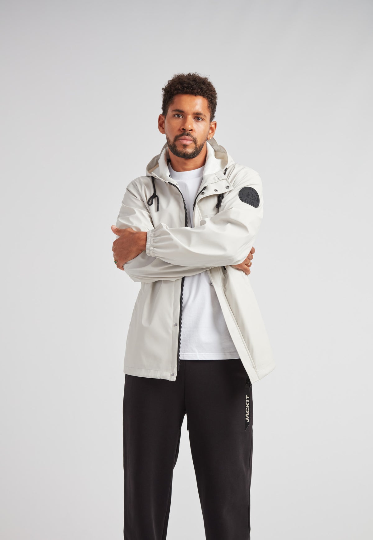 Model wearing ELEMENTS Unisex Raincoat 2.0 Stone, showcasing a stylish and functional waterproof design.