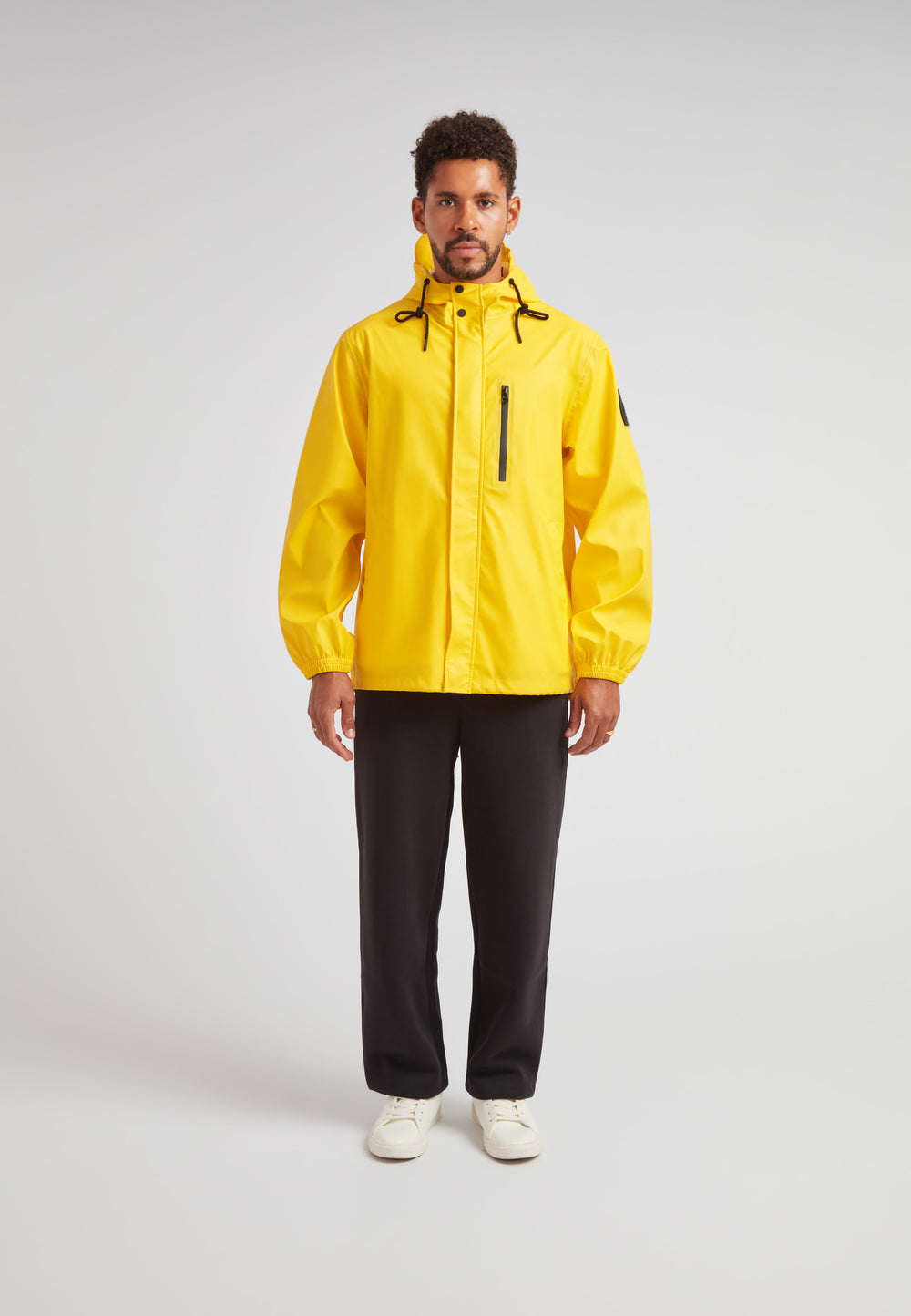 Model wearing ELEMENTS Unisex Raincoat 2.0 Yellow, standing against a neutral background.