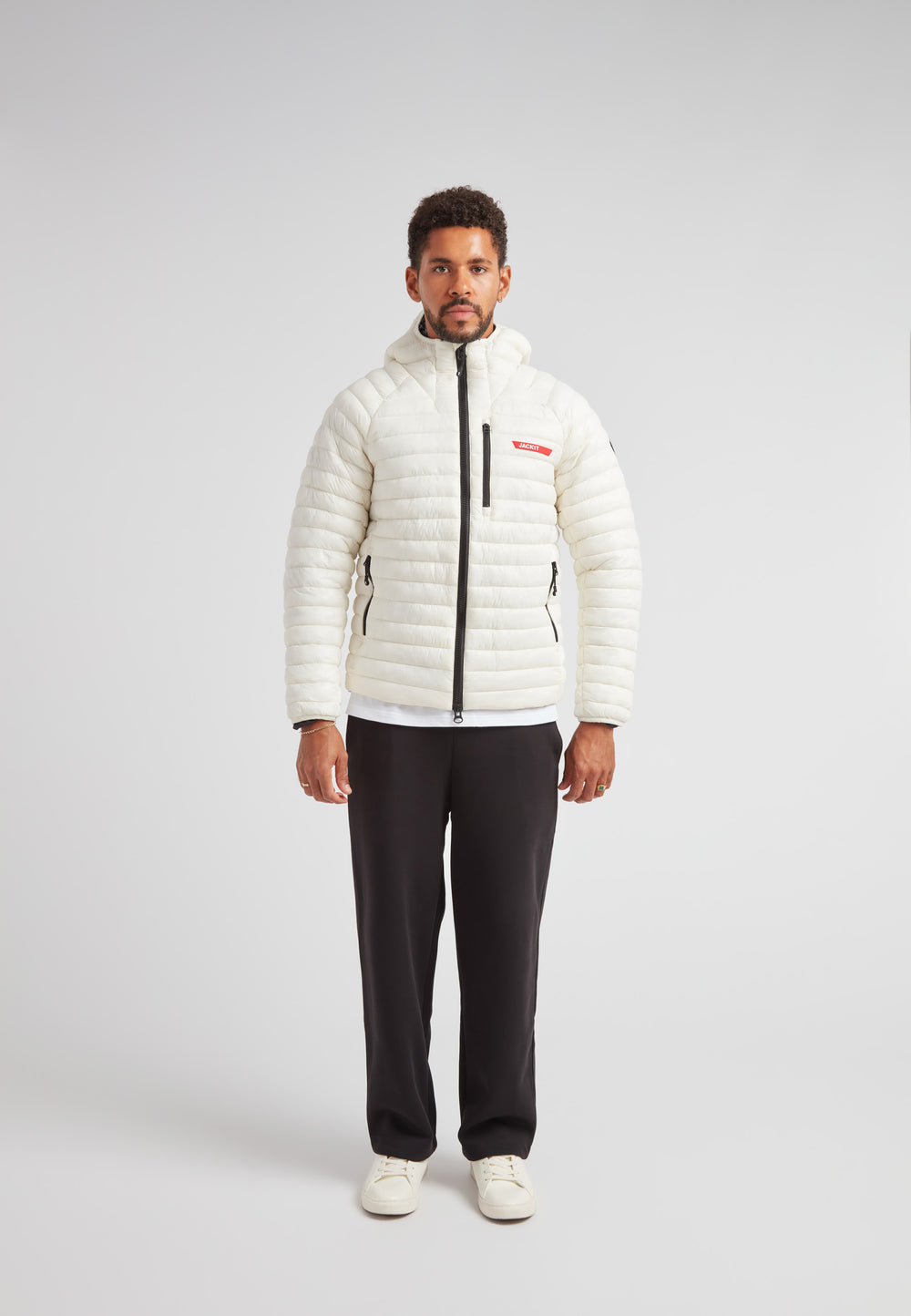 A model wearing the SATEL1TE Hooded Jacket 2.0, a white insulated jacket with a hood and stylish design.