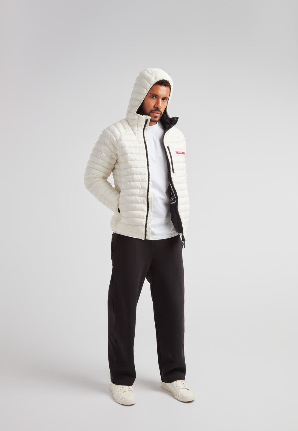 Man wearing SATEL1TE Hooded Jacket 2.0 Vintage White, showcasing its stylish hood and sleek design.