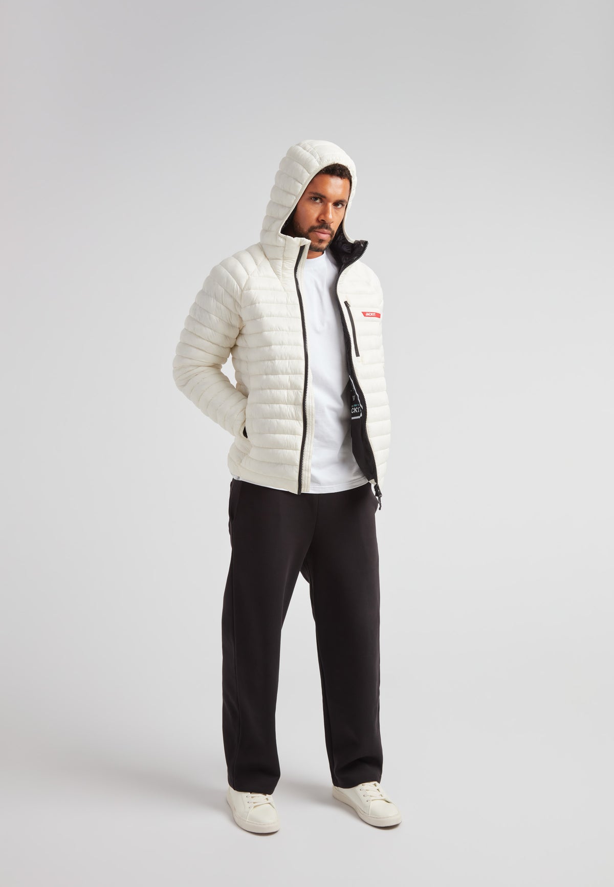 Man wearing SATEL1TE Hooded Jacket 2.0 Vintage White, showcasing its stylish hood and sleek design.