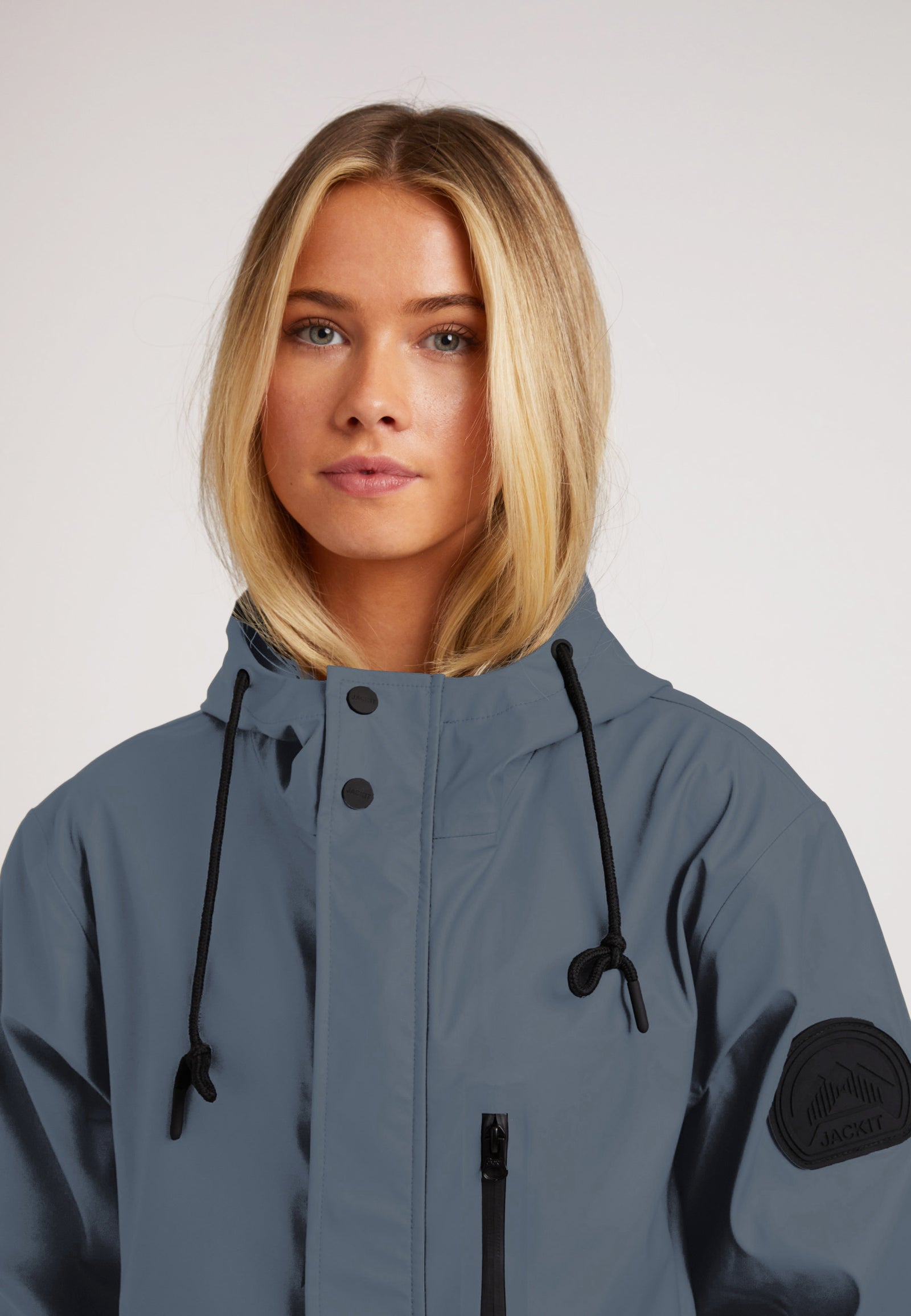 Model wearing the ELEMENTS Raincoat 2.0 Grey, featuring a hood and stylish design for outdoor comfort.