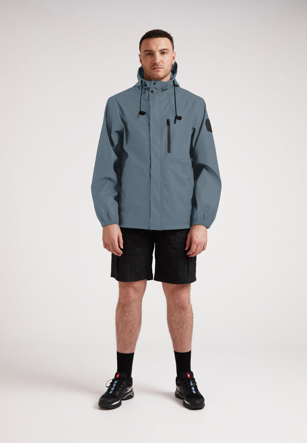 Man wearing the ELEMENTS Unisex Raincoat 2.0 Grey, showcasing its stylish design and versatility.