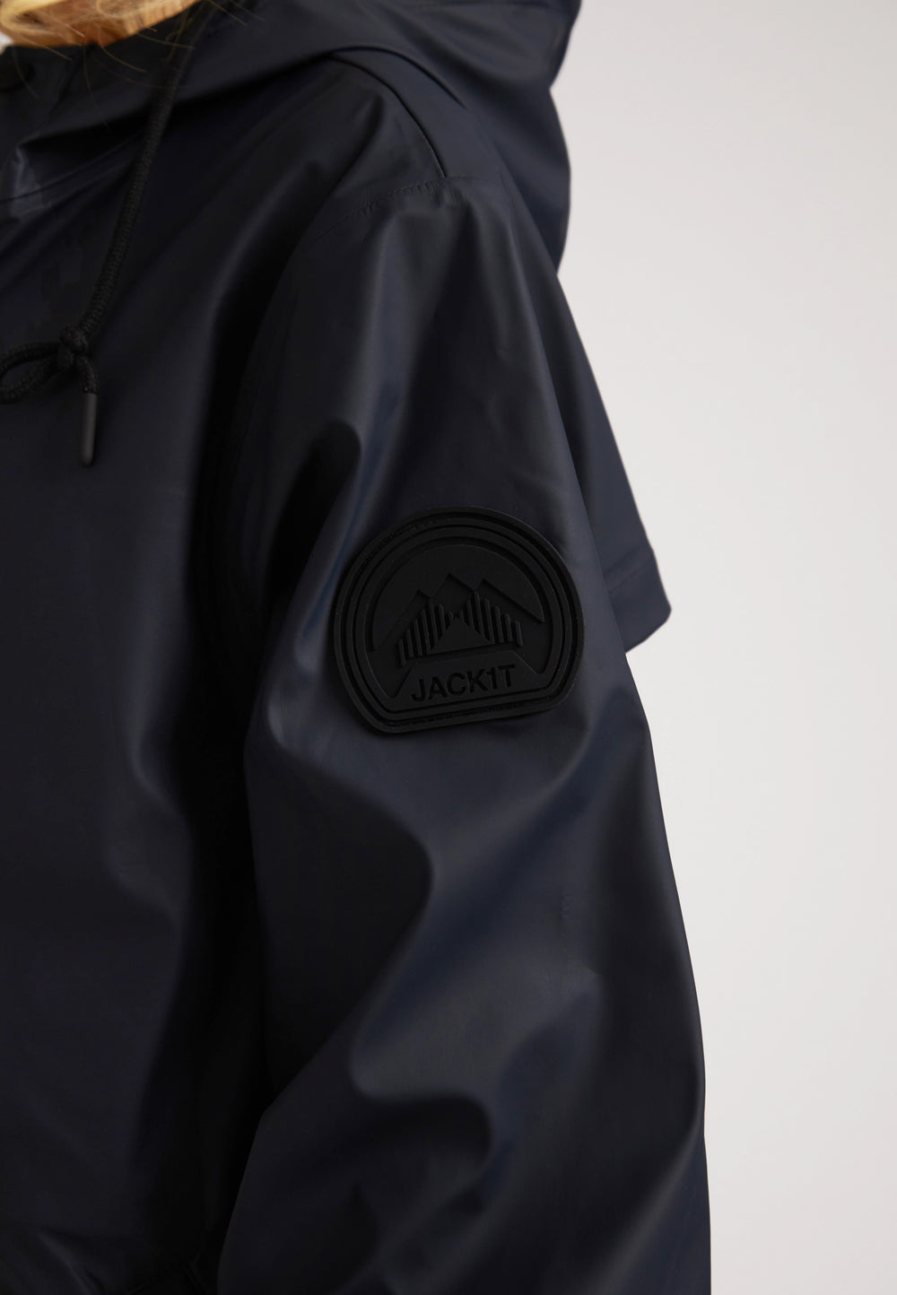 Close-up of the ELEMENTS Raincoat 2.0 Navy featuring a logo patch on the sleeve.