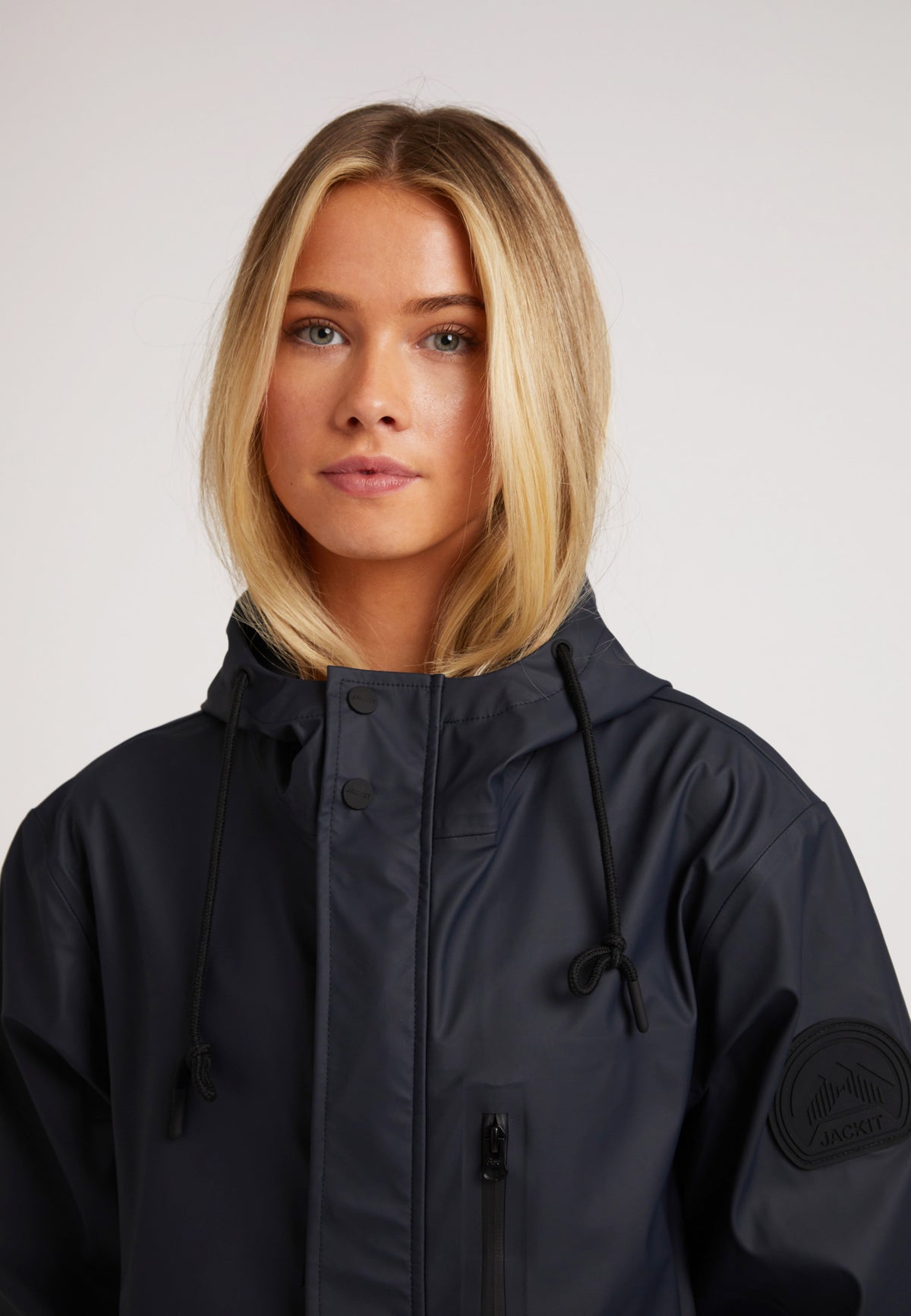 Close-up of a model wearing the ELEMENTS Raincoat 2.0 Navy, showcasing its sleek design and hood.