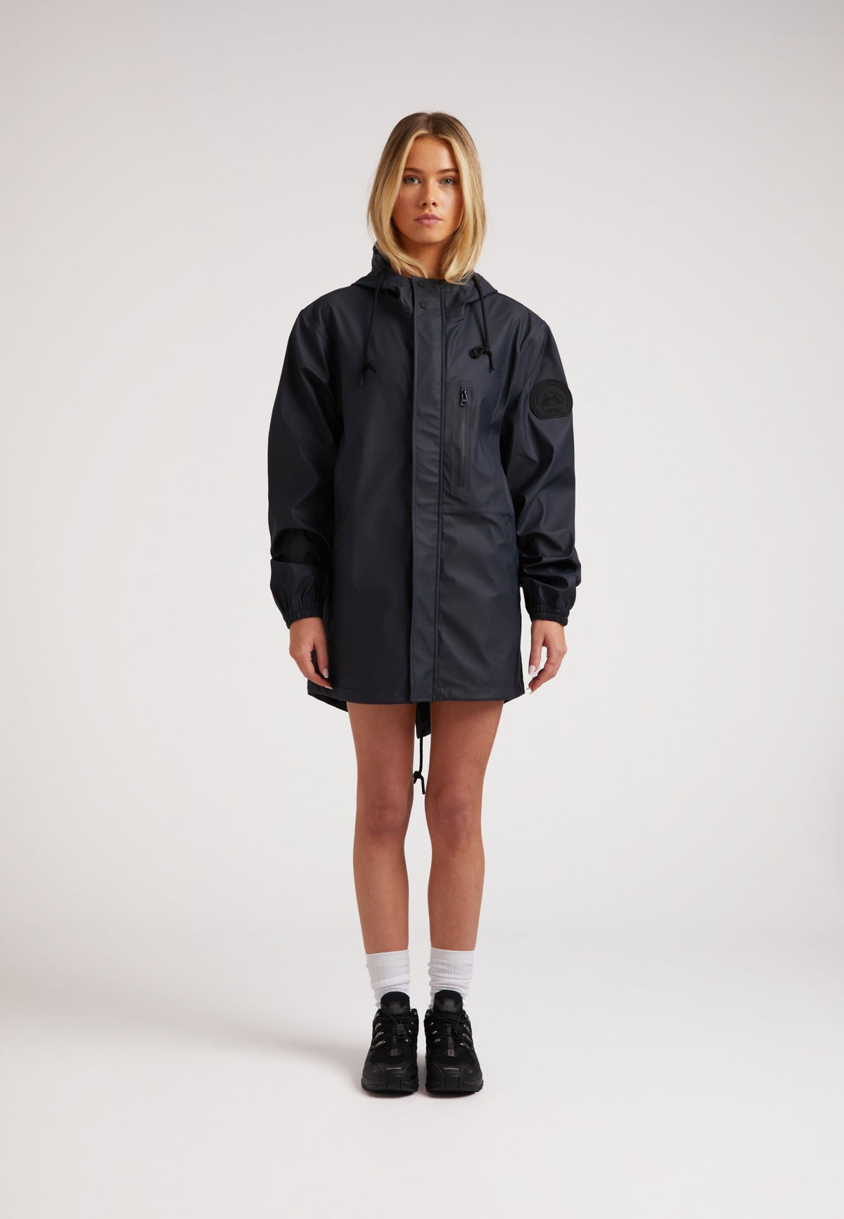 Model wearing ELEMENTS Raincoat 2.0 Navy, a lightweight rain jacket designed for comfort and breathability.