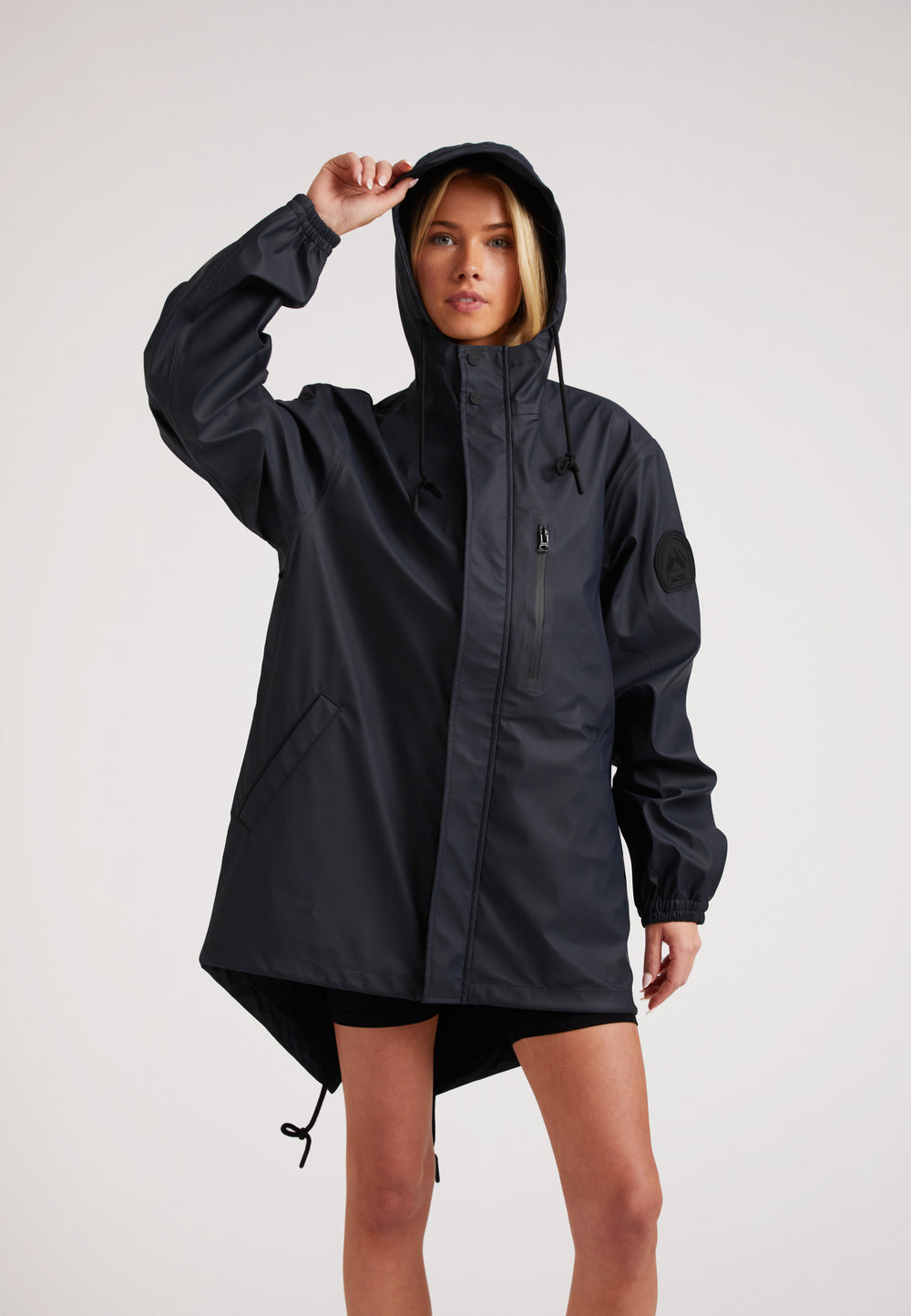Model wearing ELEMENTS Raincoat 2.0 Navy, a lightweight rain jacket designed for comfort and breathability.
