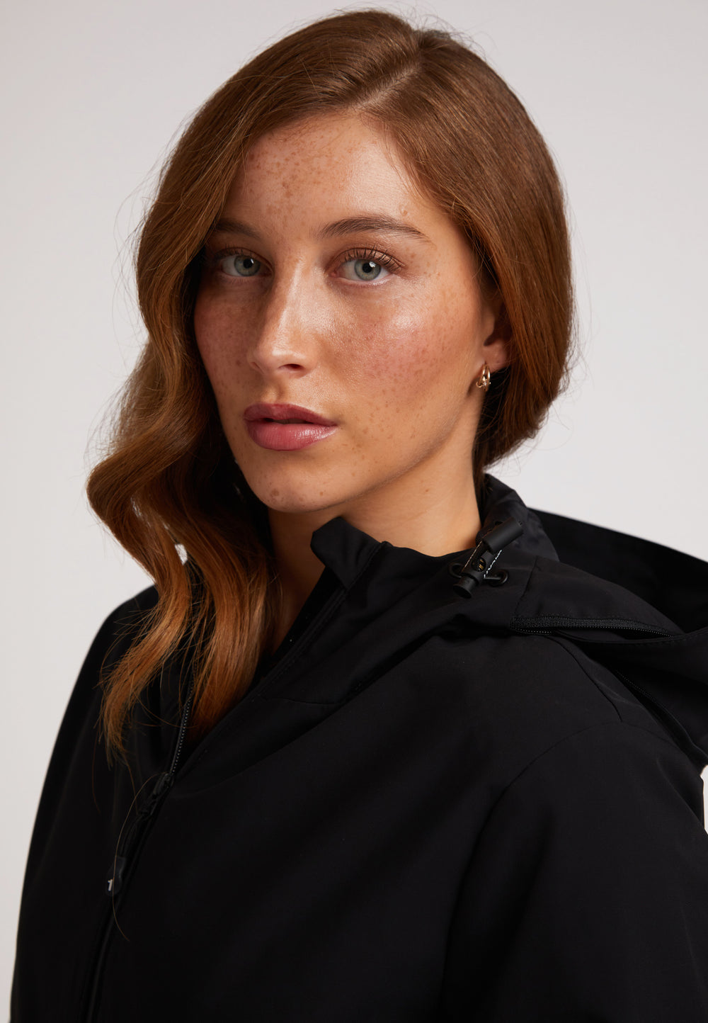 Model wearing the HELIO Mid Windbreaker Black, showcasing its sleek design and waterproof features.