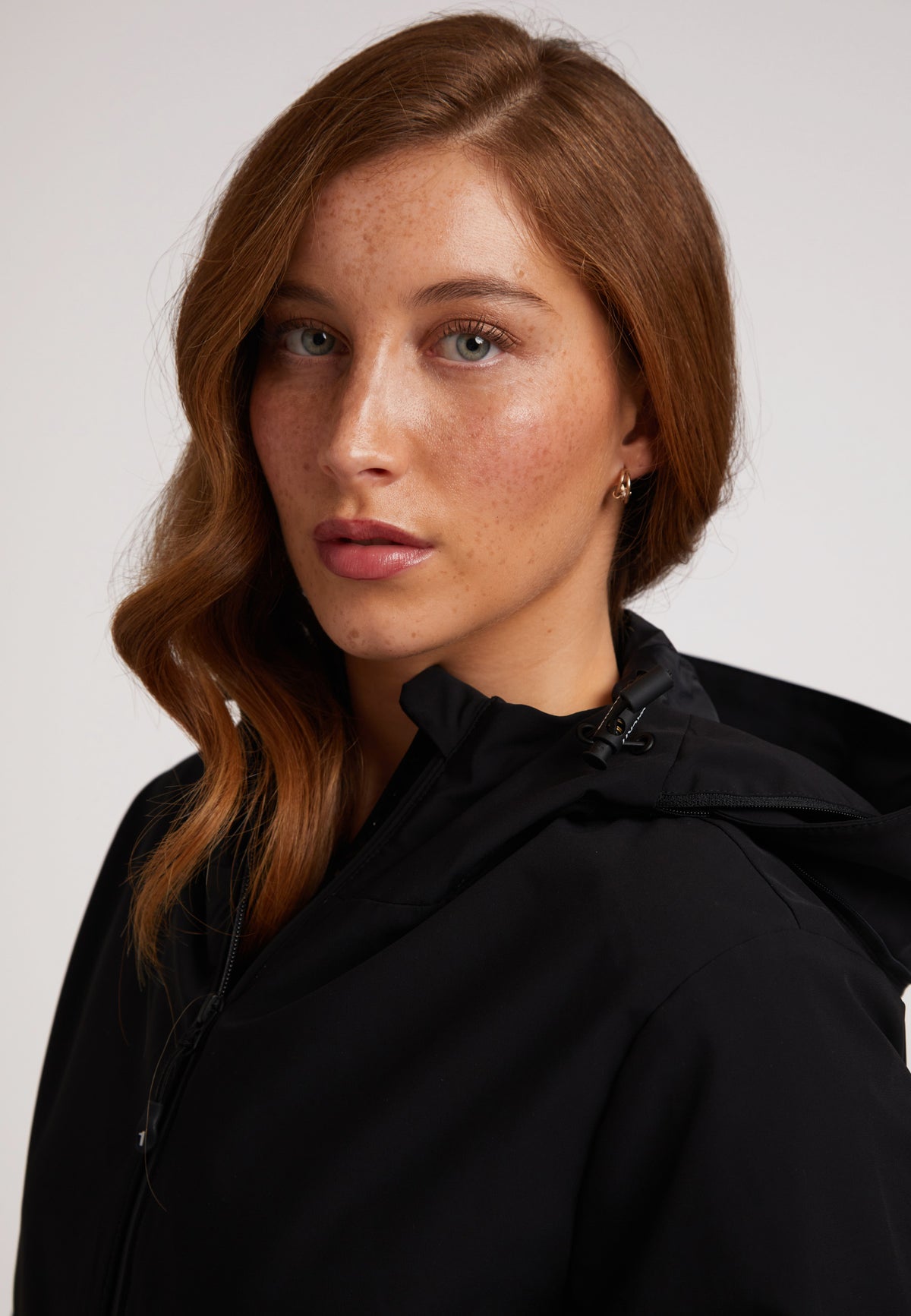 Model wearing the HELIO Mid Windbreaker Black, showcasing its sleek design and waterproof features.