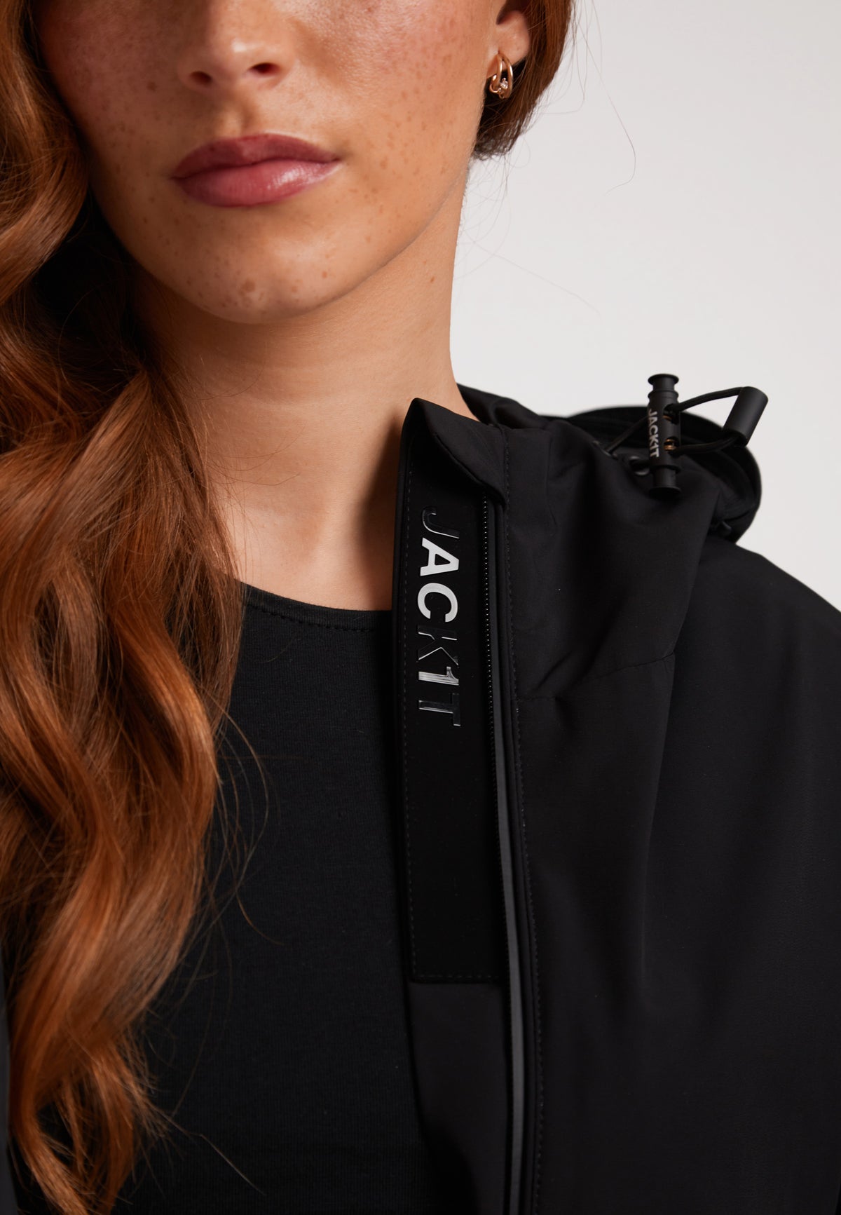 Model wearing HELIO Mid Windbreaker Black with a stylish hood and zip detail showcasing sleek design.