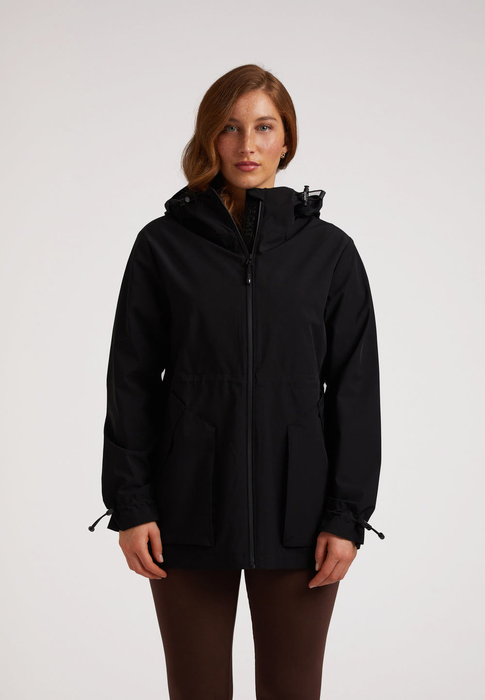 Woman wearing the HELIO Mid Windbreaker Black, showcasing its stylish design and functional features.