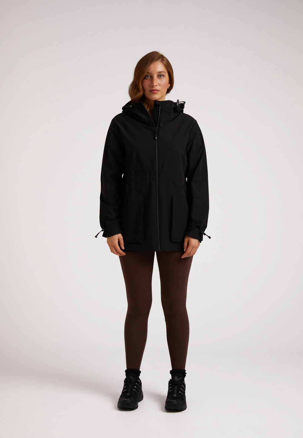 Model wearing HELIO Mid Windbreaker Black with a hood, showcasing its stylish and functional design.