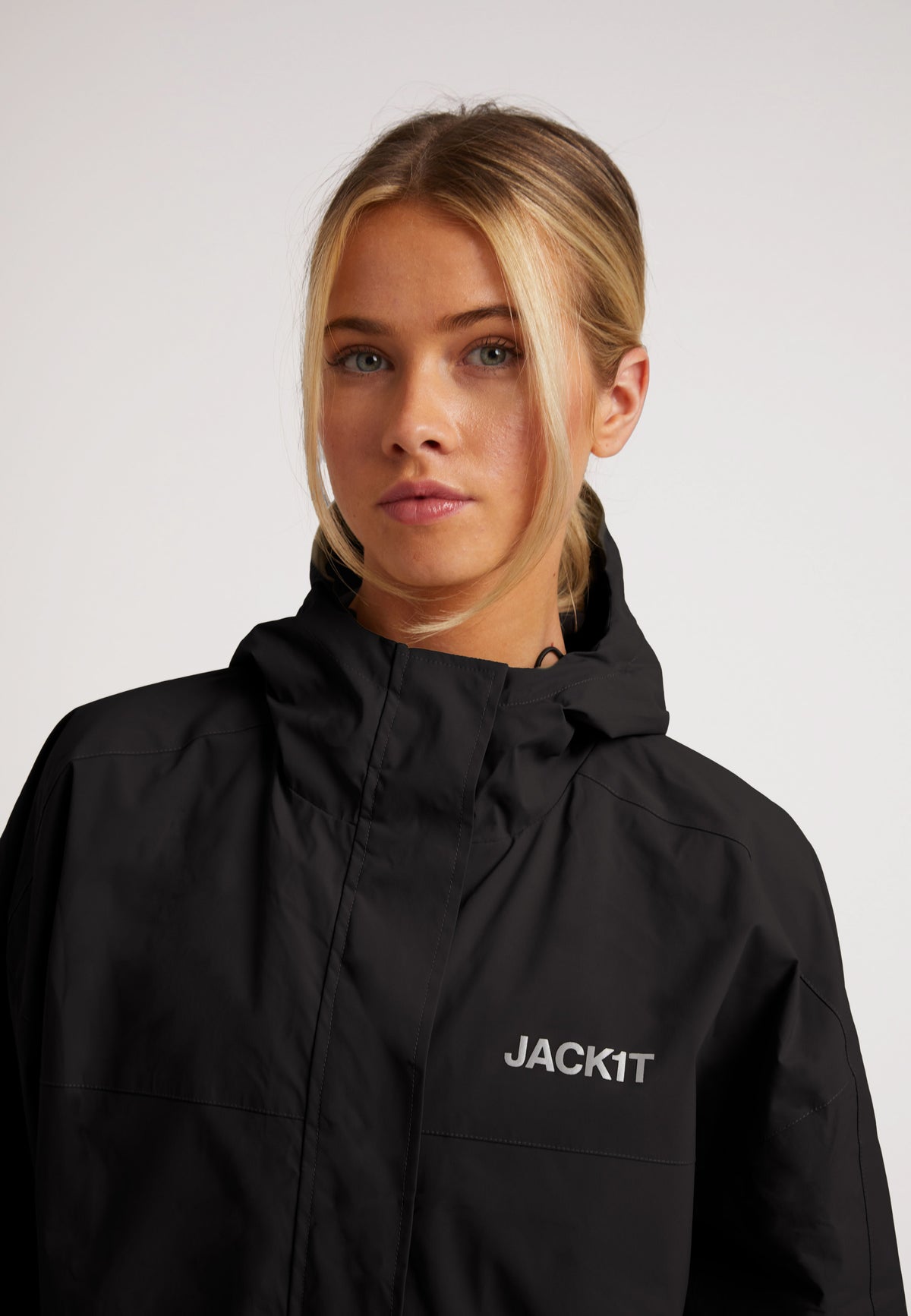 Model wearing an ISOTOPE lightweight windbreaker, showcasing the durable black fabric and stylish design for ladies.