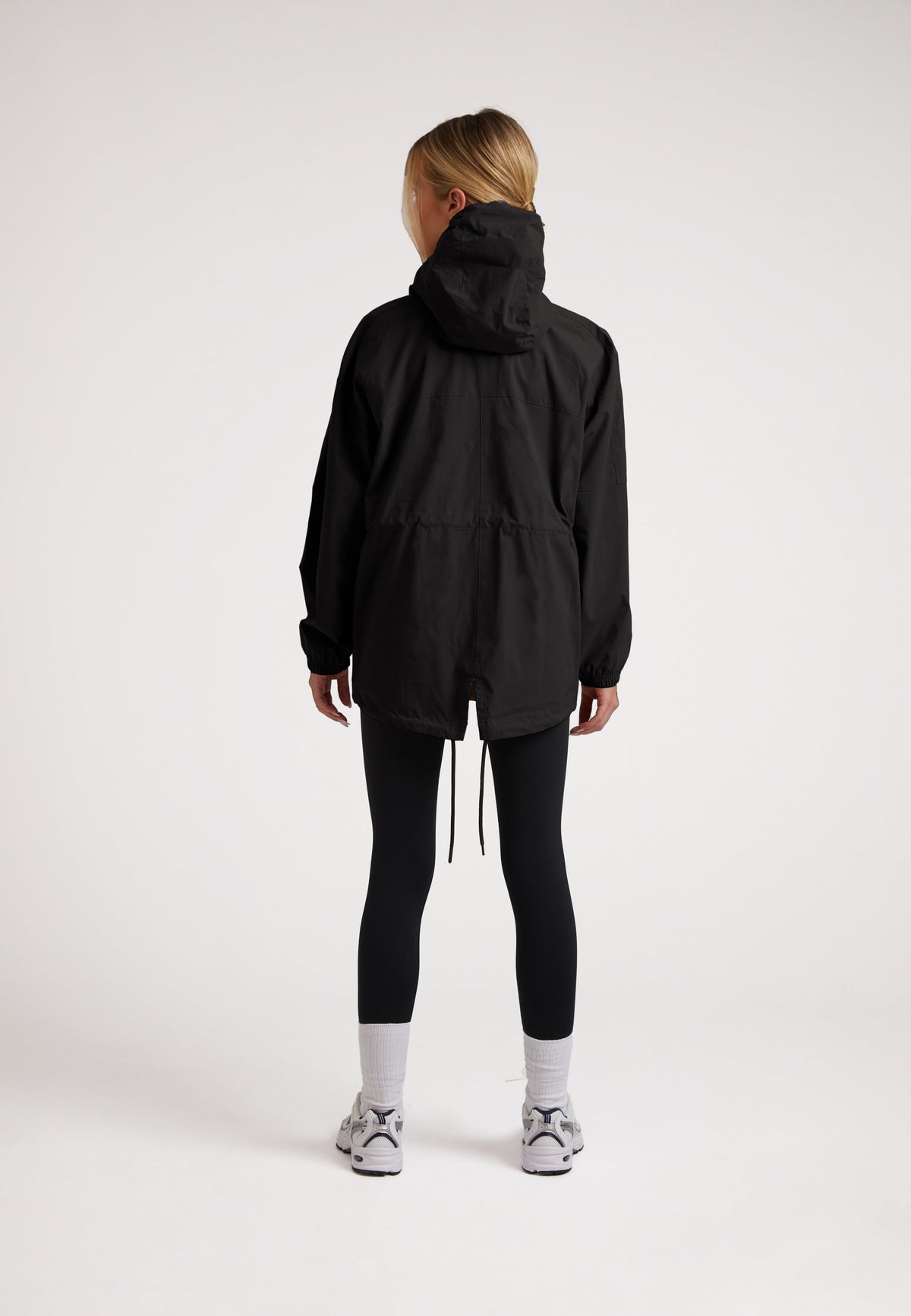 Back view of a model wearing the ISOTOPE Lightweight Windbreaker, showcasing a ladies lightweight black windbreaker design.
