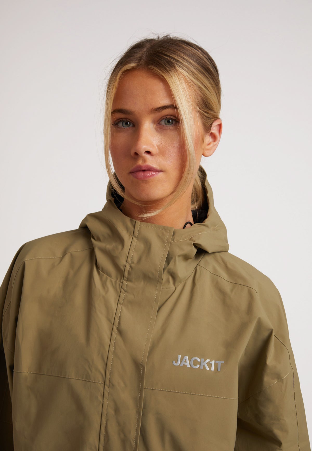Model wearing ISOTOPE lightweight windbreaker in olive, showcasing its stylish design and features.