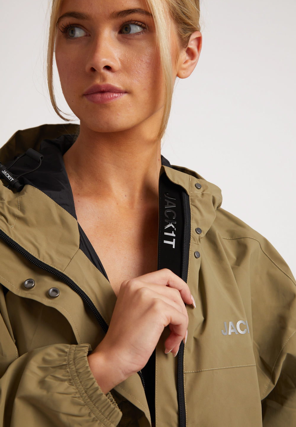 Model wearing a ladies lightweight olive windbreaker, showcasing the jacket's features and style.