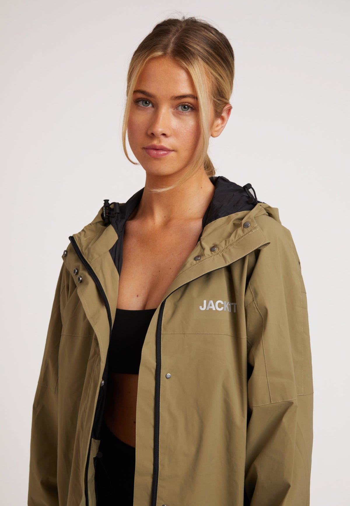 Model wearing ISOTOPE lightweight windbreaker, showcasing Ladies lightweight olive windbreaker design and features.