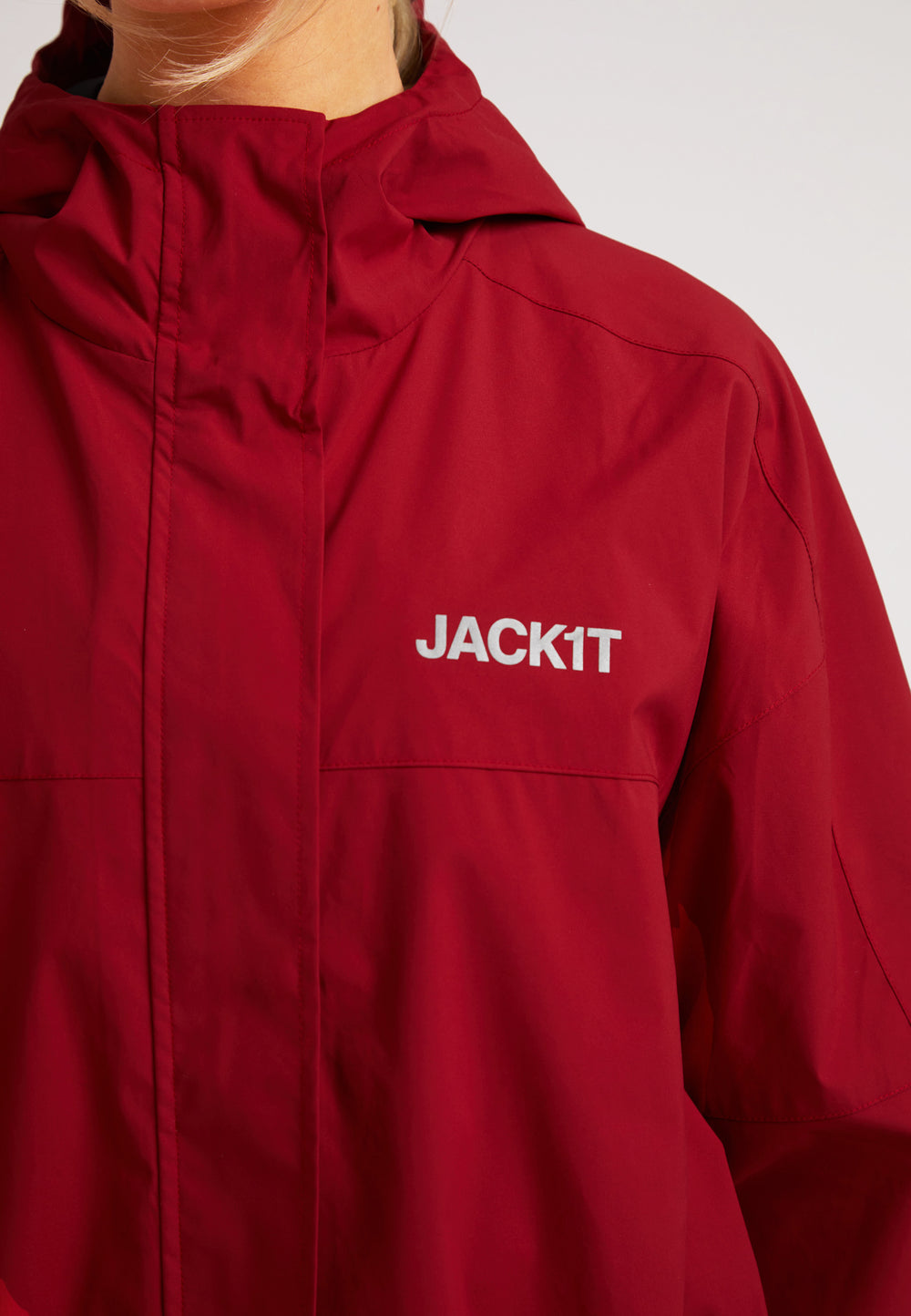 Ladies red lightweight windbreaker by JACK1T featuring a hood and durable fabric.