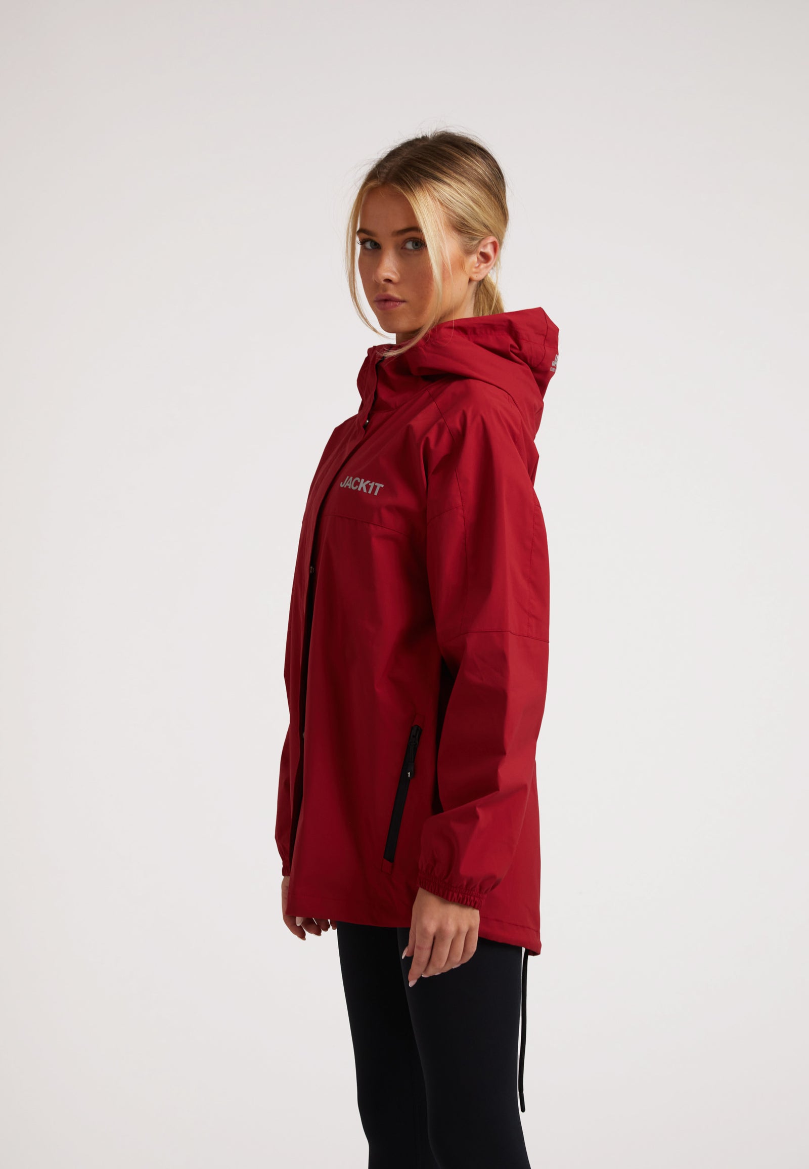 Ladies red lightweight windbreaker featuring durable water repellent fabric and windproof design.