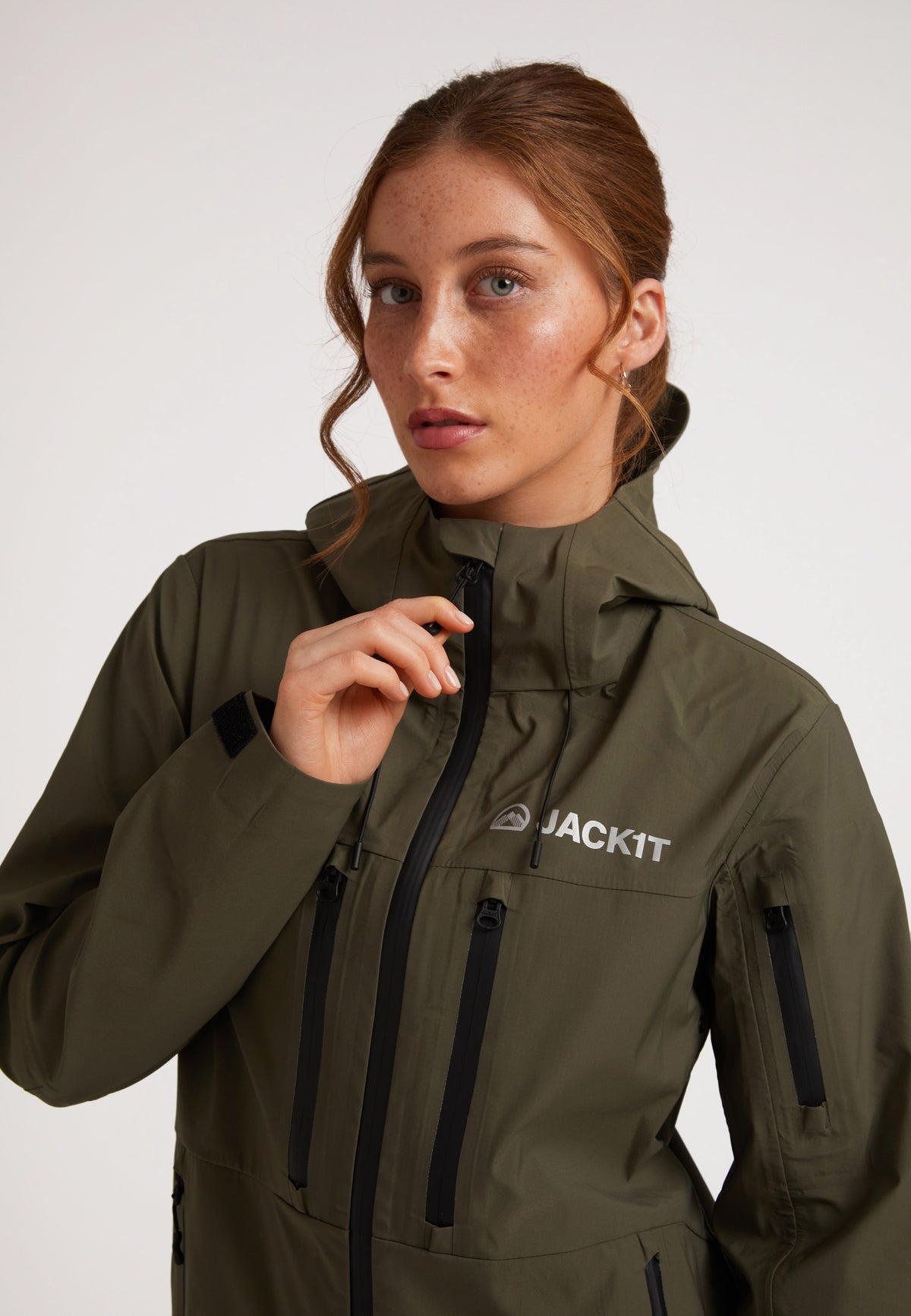Waterproof ladies jacket in olive worn by a model showcasing its stylish design and functionality.