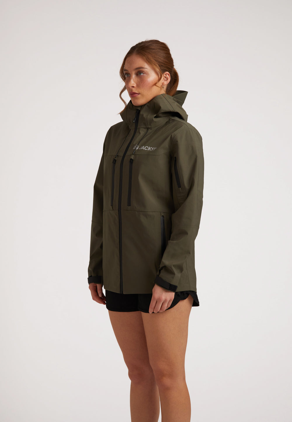 Waterproof ladies jacket in olive, featuring a hood and multiple pockets, designed for outdoor protection.
