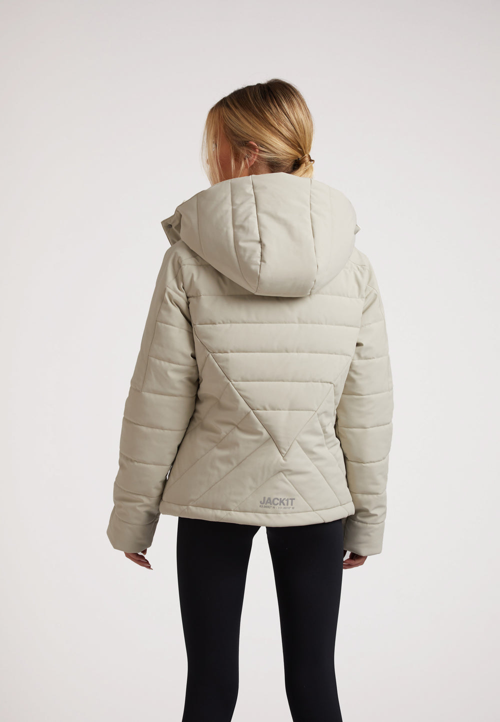 Back view of a model wearing an ISOTOPE Ladies padded lightweight stone jacket with hood.