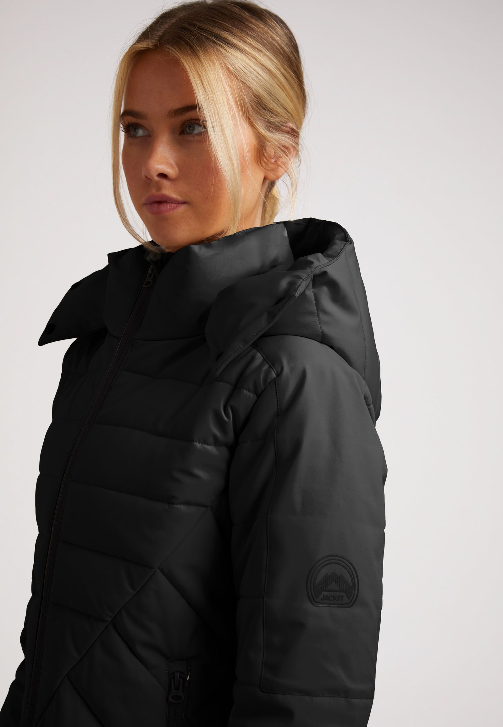 ISOTOPE Padded Jacket Black on a model, featuring windproof design and adjustable hood for warmth and performance.