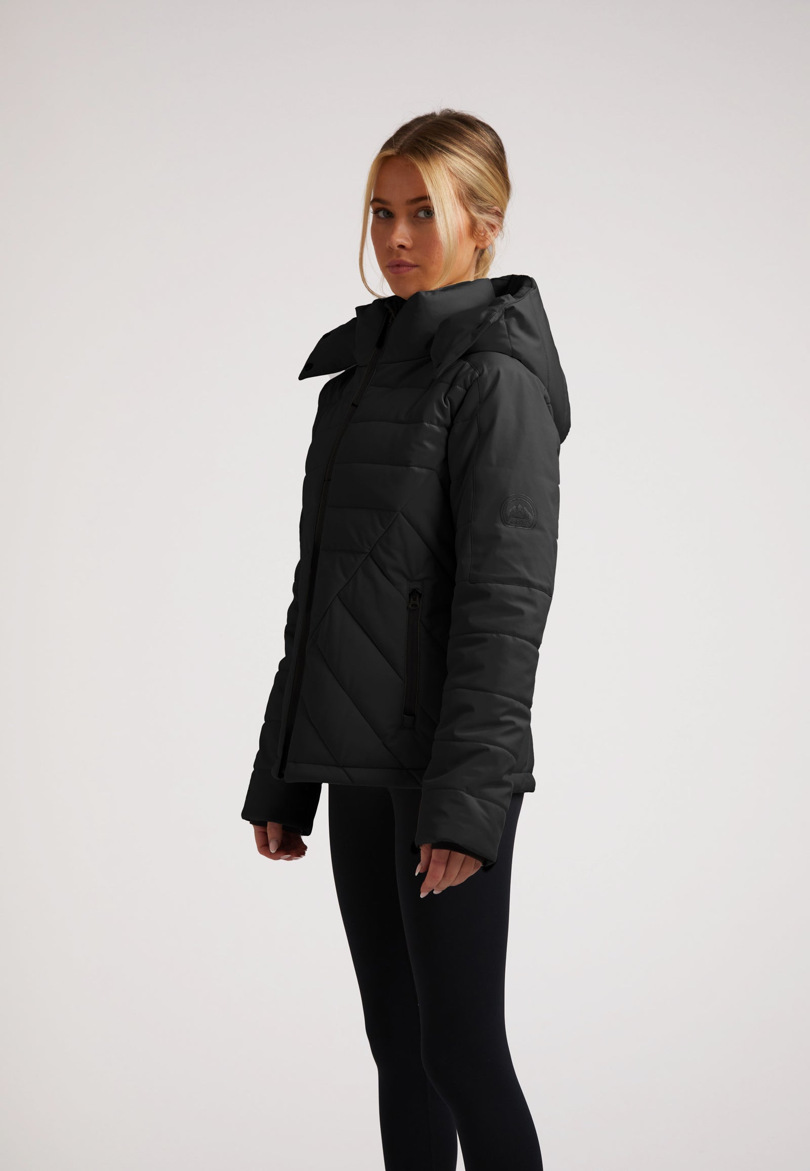 ISOTOPE Padded Jacket Black shown on model, featuring a stylish padded design and adjustable hood.