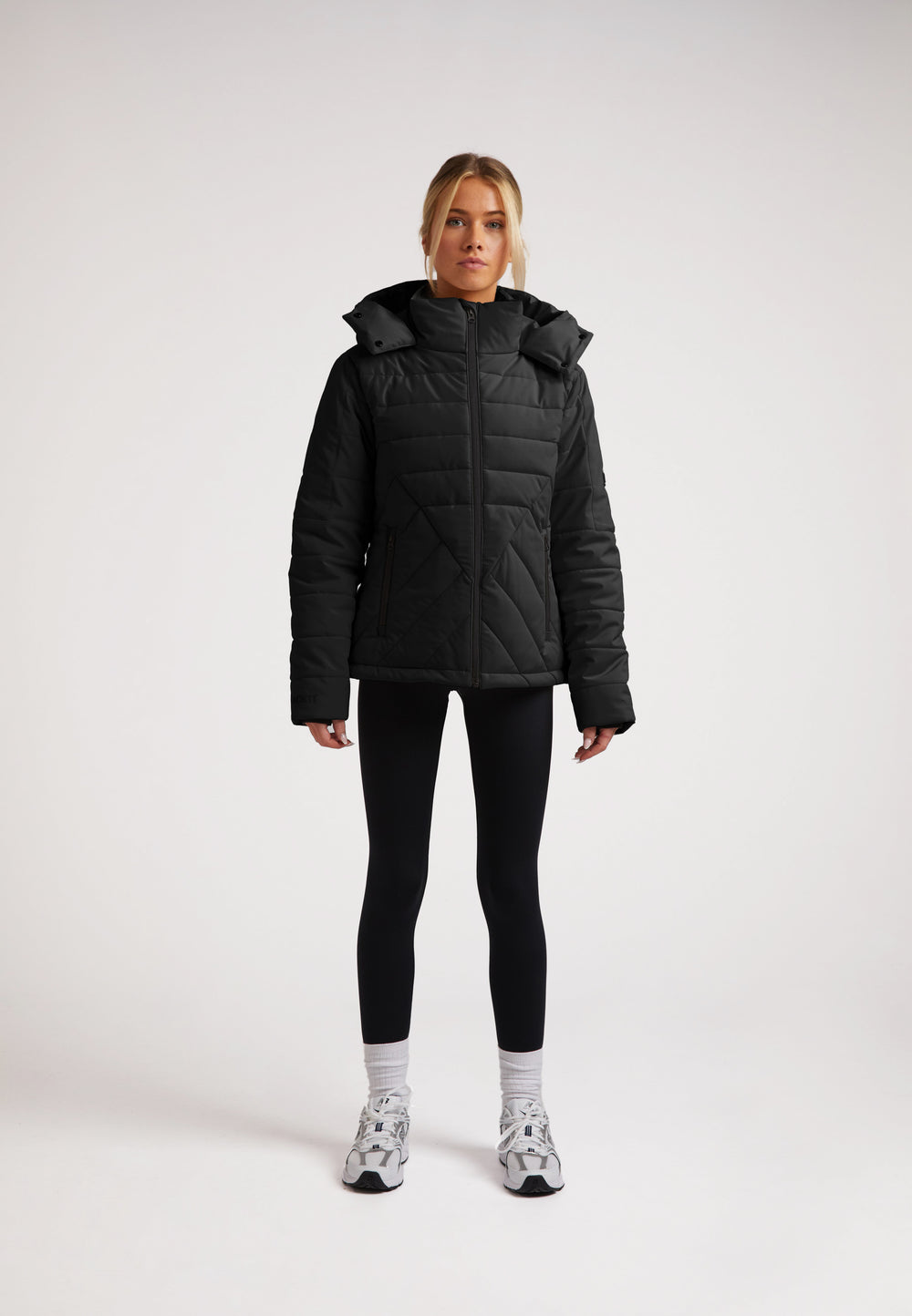 ISOTOPE Padded Jacket Black worn by model, featuring windproof design and adjustable hood for warmth and performance.