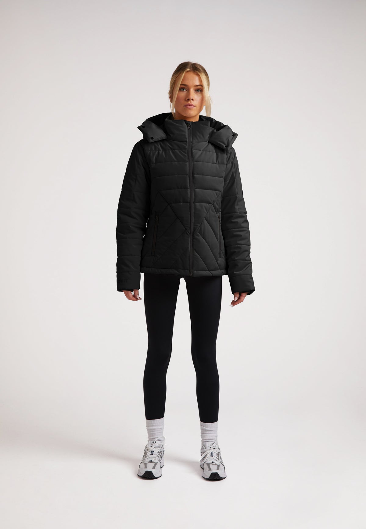 ISOTOPE Padded Jacket Black worn by model, featuring windproof design and adjustable hood for warmth and performance.