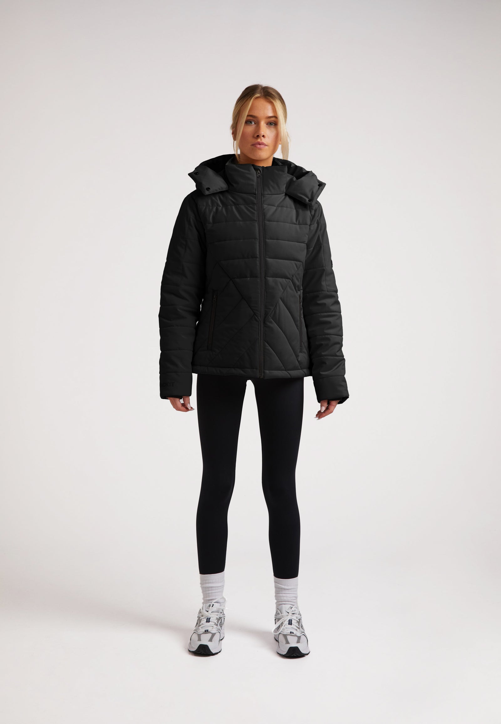 ISOTOPE Padded Jacket Black worn by model, featuring windproof design and adjustable hood for warmth and performance.