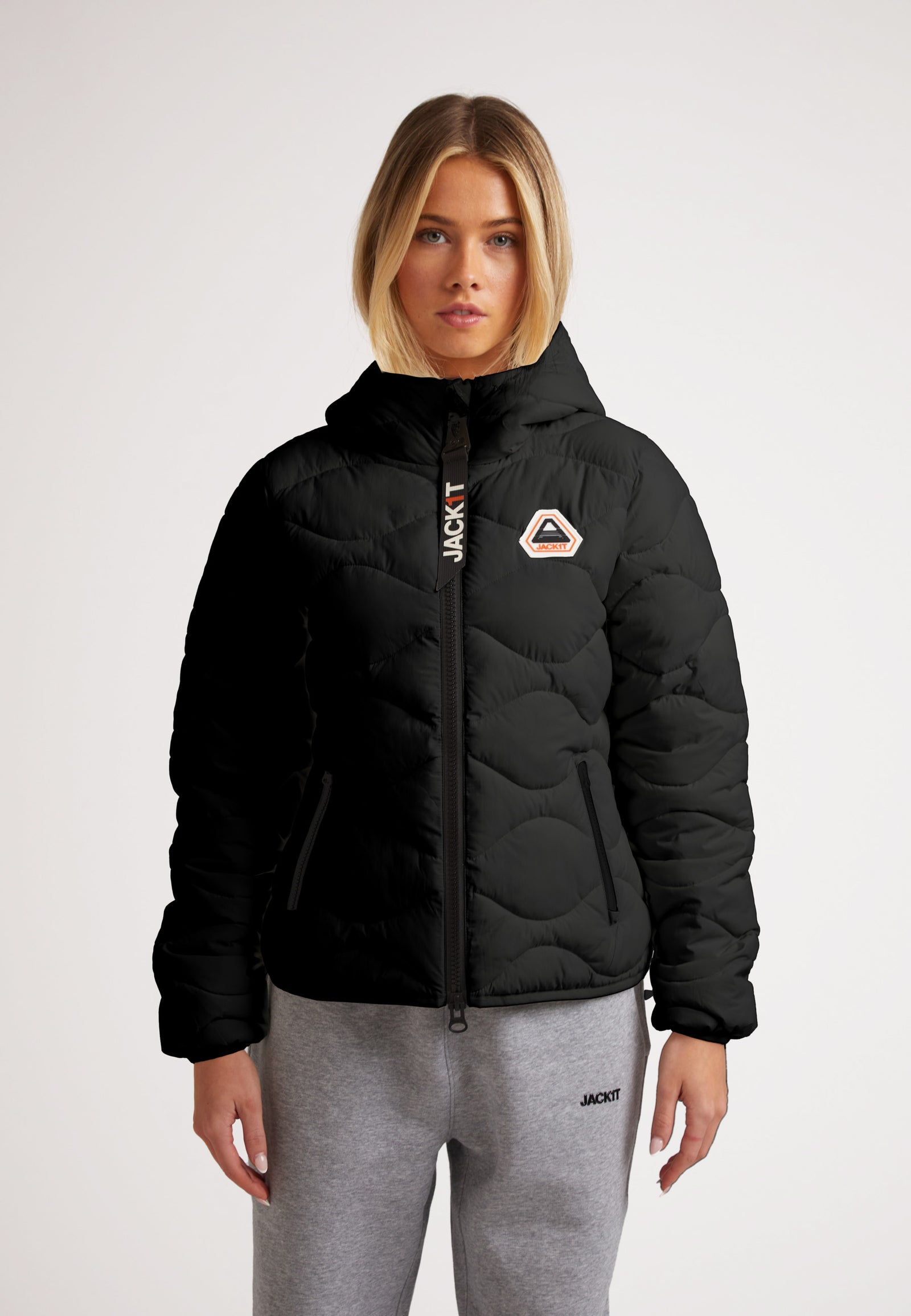 Woman wearing ORB1T Quilted Puffer Jacket with onion baffle design and soft touch fabric, ideal for cold weather.