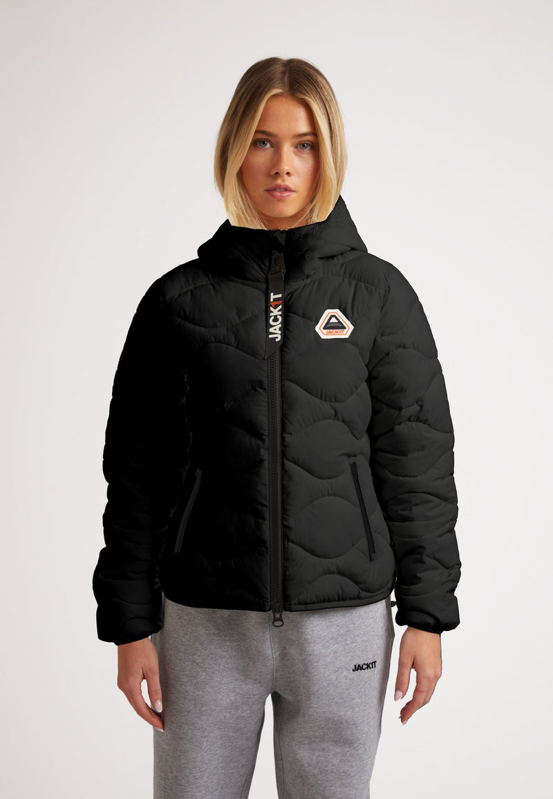 Woman wearing ORB1T Quilted Puffer Jacket with onion baffle design and soft touch fabric, ideal for cold weather.