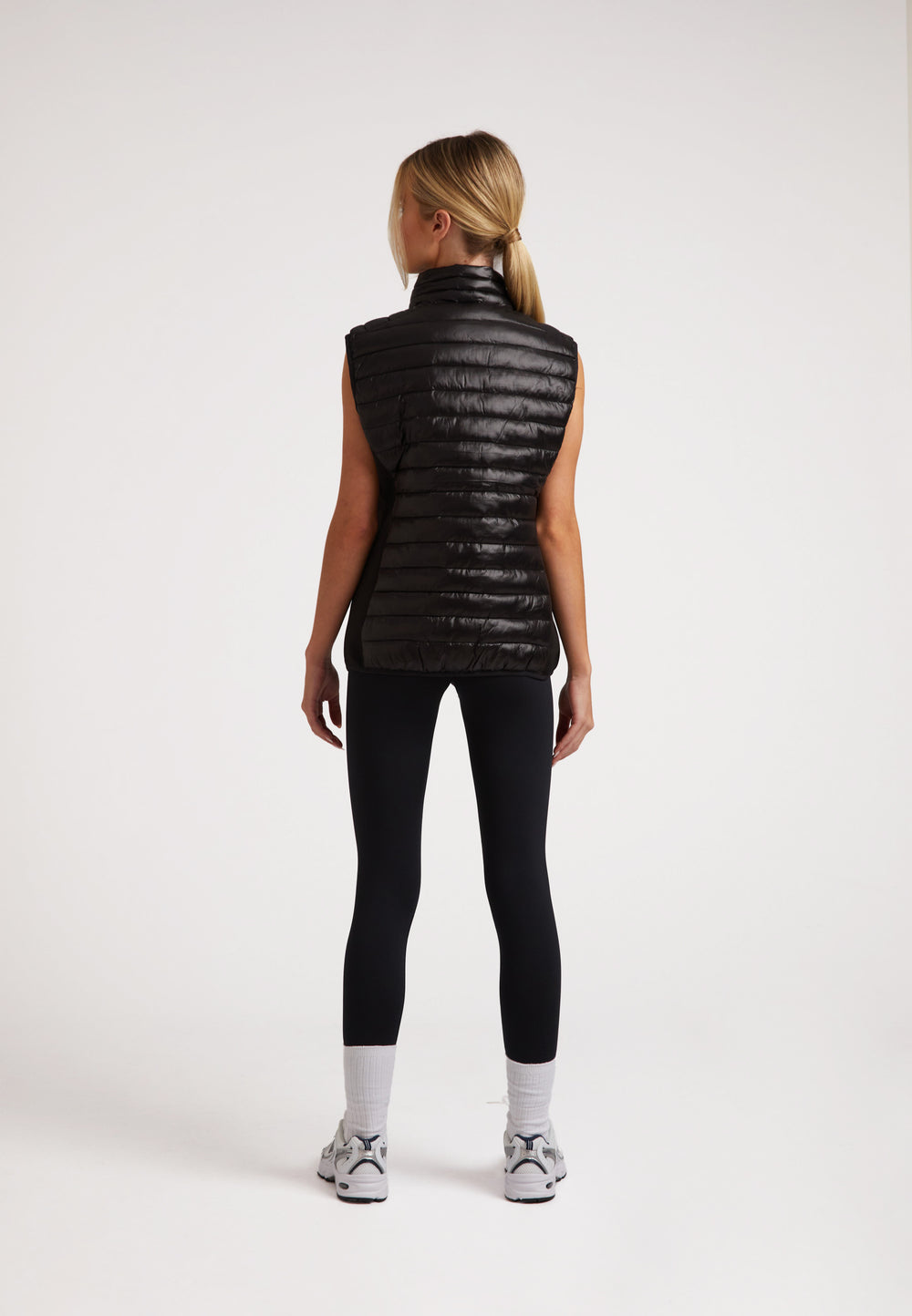 Back view of a model wearing the SPORTL1TE Funnel Lightweight Gilet 2.0 Lux Black, showcasing its sleek design and lightweight fabric.