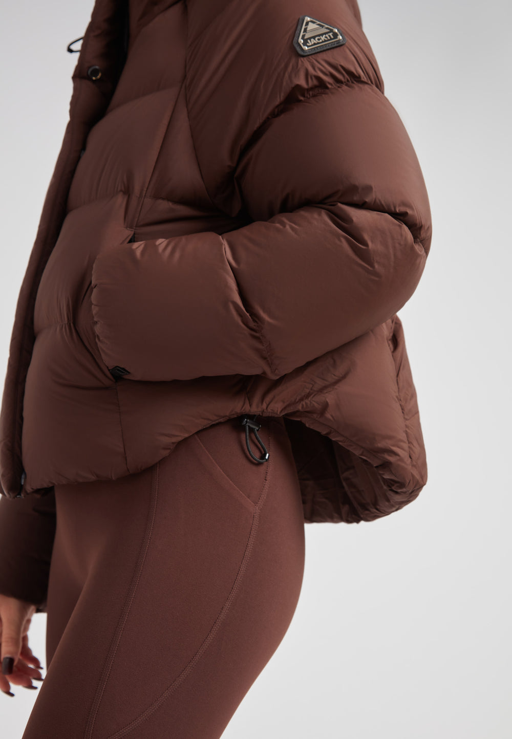 Ladies Cloud Crop Down Puffer Jacket in Mid Brown displayed with stylish details and a cozy fit.