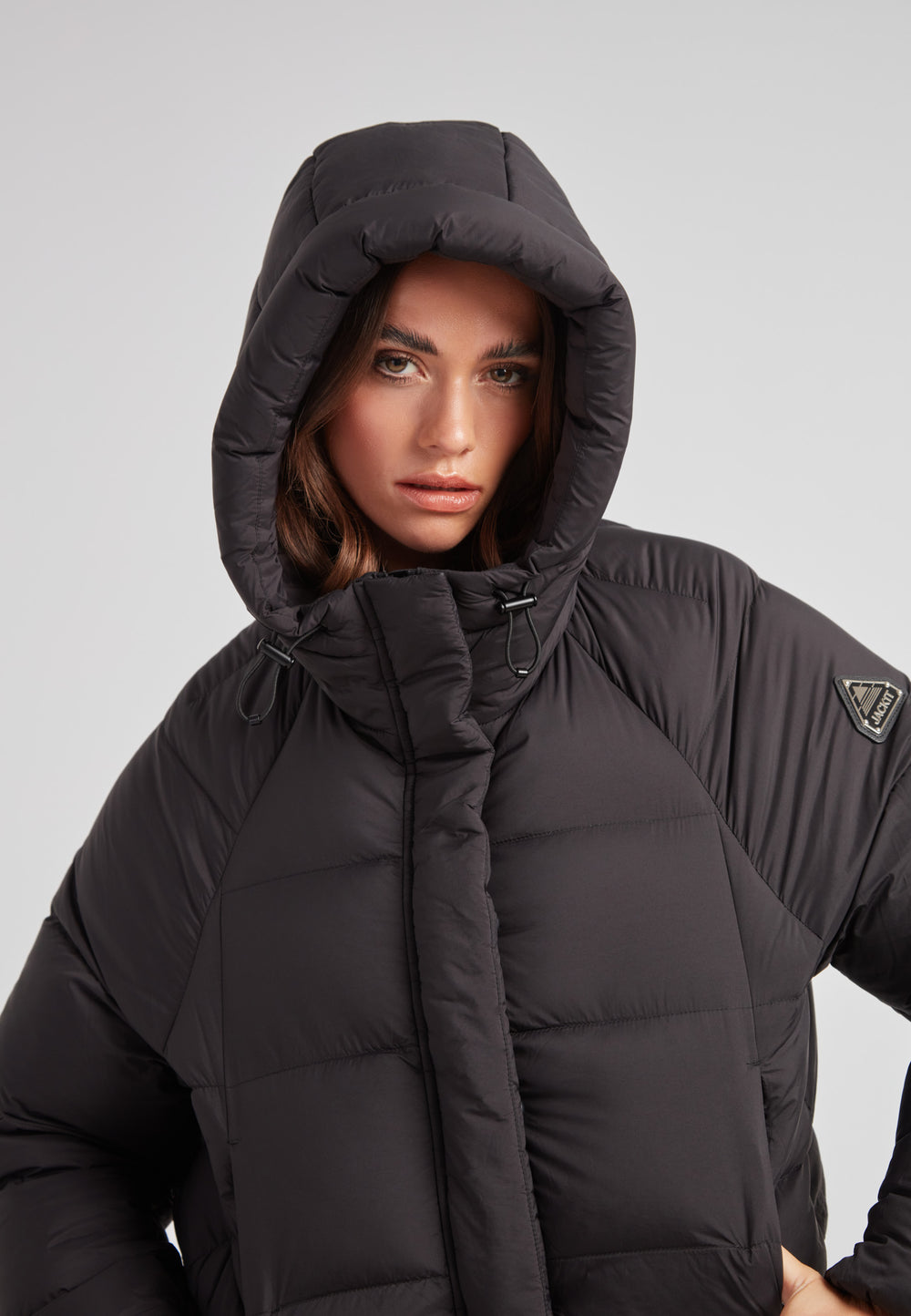 Model wearing Cloud Crop Down Puffer Jacket Black with oversized hood, showcasing lightweight construction and stylish design.