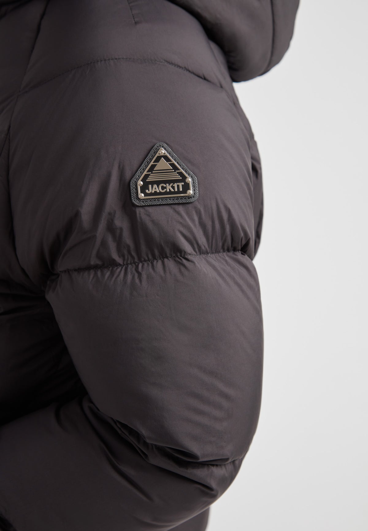 Close-up of JACK1T logo on the Cloud Crop Down Puffer Jacket Black showcasing its unique design.