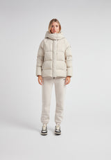 Woman wearing Cloud Prime Longline Down Puffer Jacket Stone, showcasing its stylish and warm design.