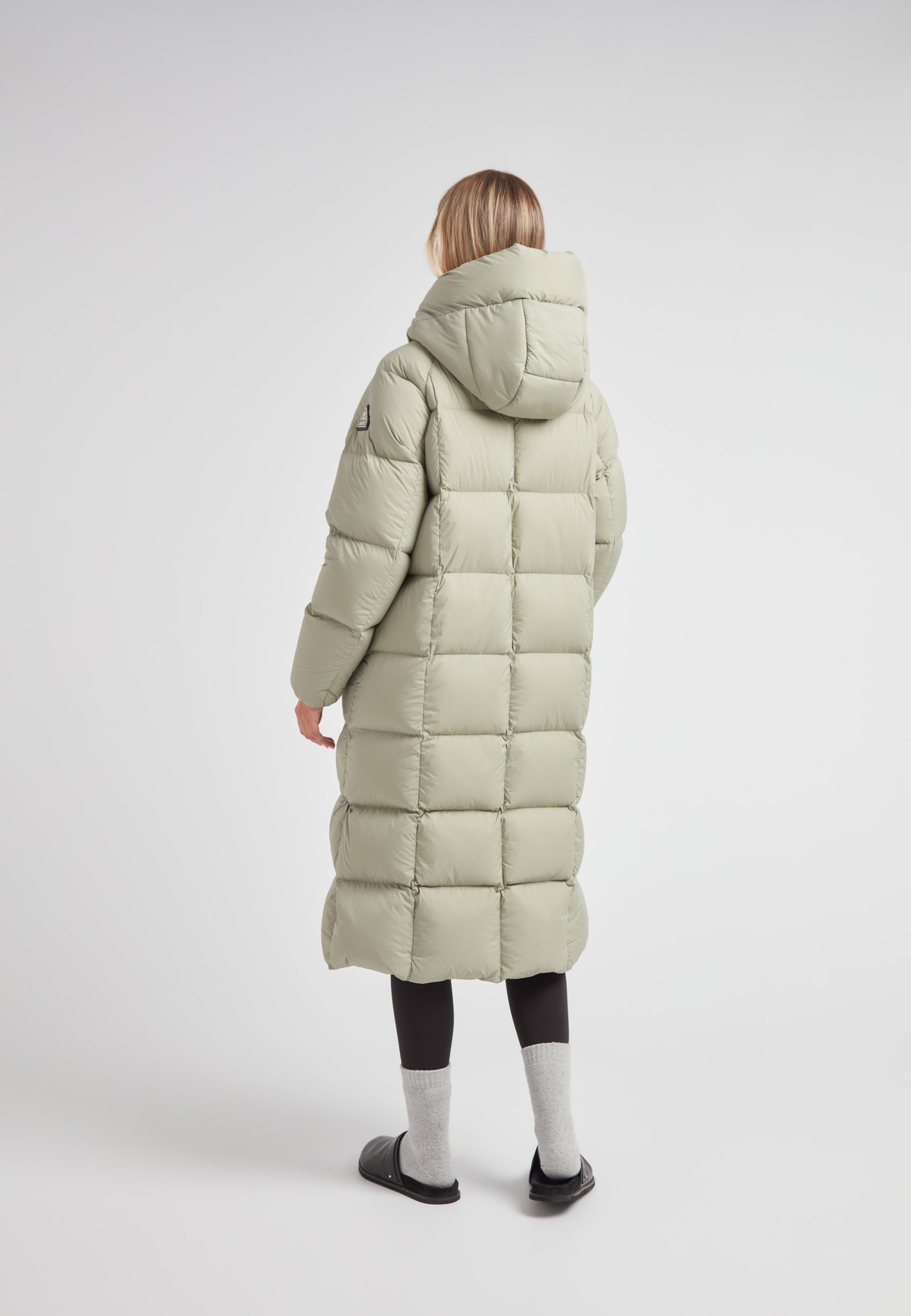 Back view of a woman wearing a Cloud Ultra Long Down Puffer Coat with a hood and ankle-length design.