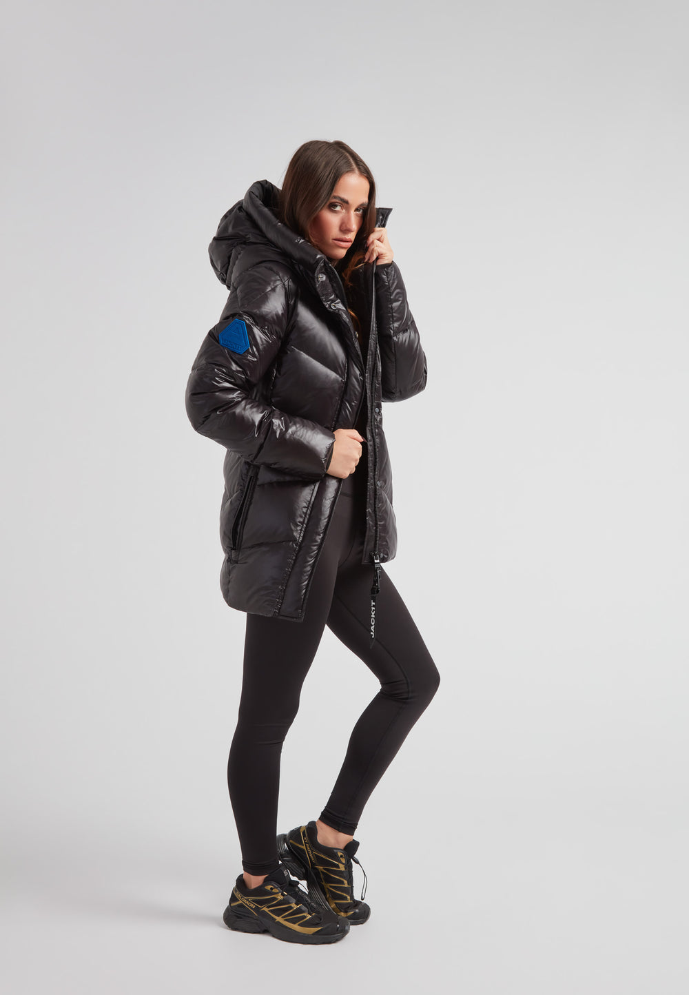 black thigh-length womens slick coat on a model, showcasing mid-length silhouette and stylish design.