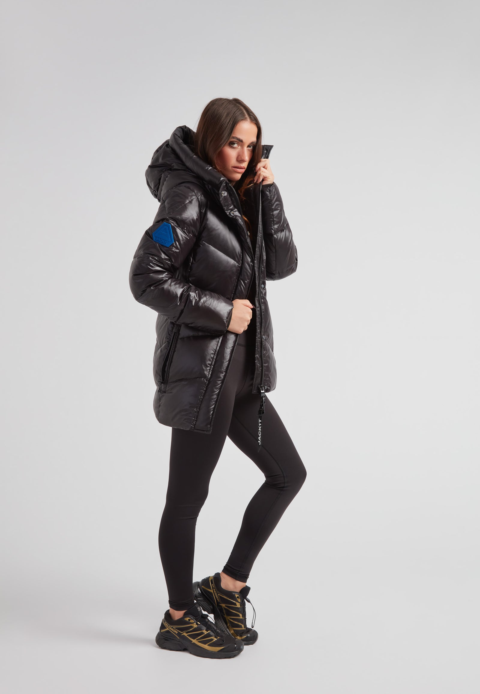 black thigh-length womens slick coat on a model, showcasing mid-length silhouette and stylish design.