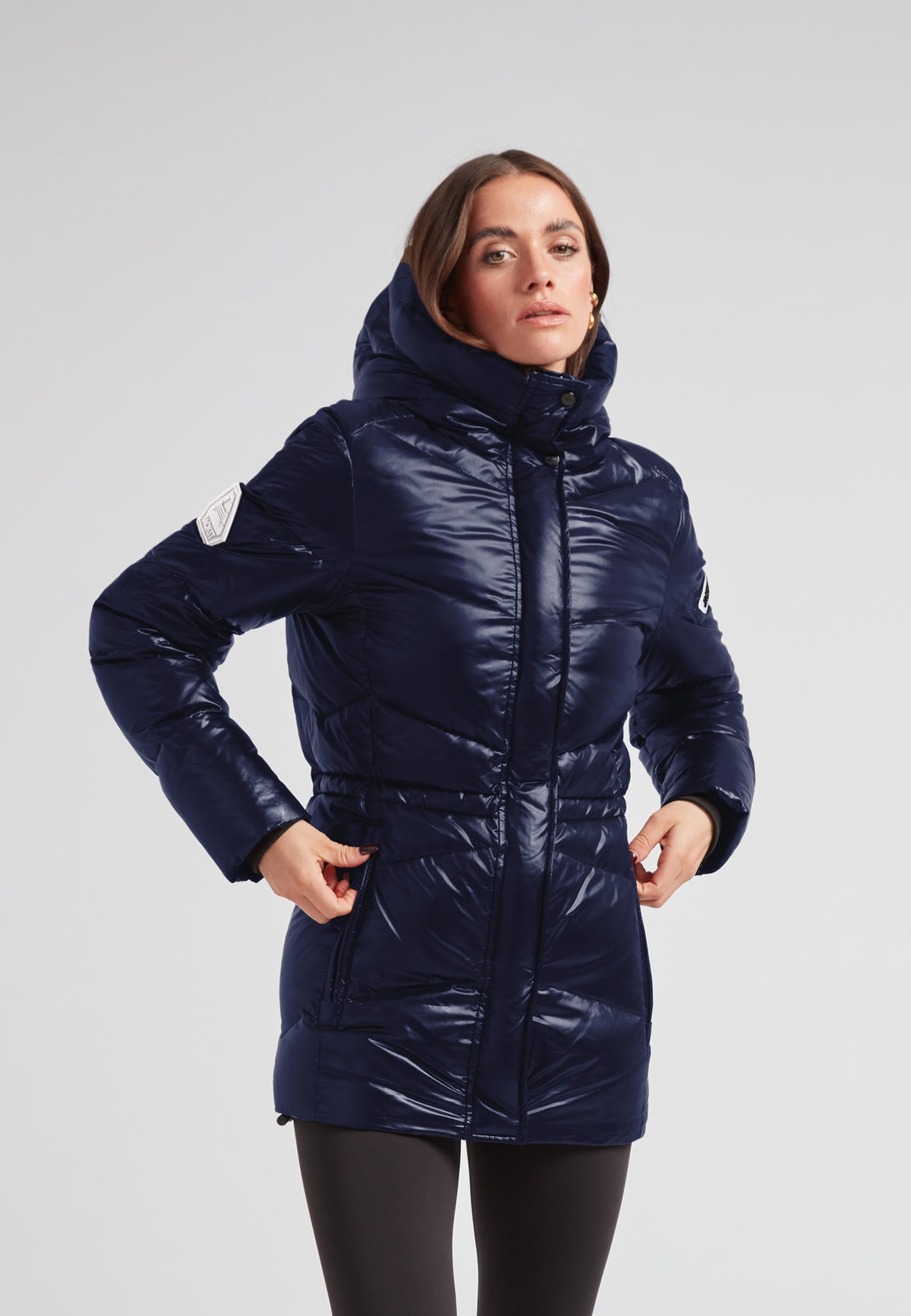 Womens navy down puffer coat featuring a mid-length silhouette and a stylish design.