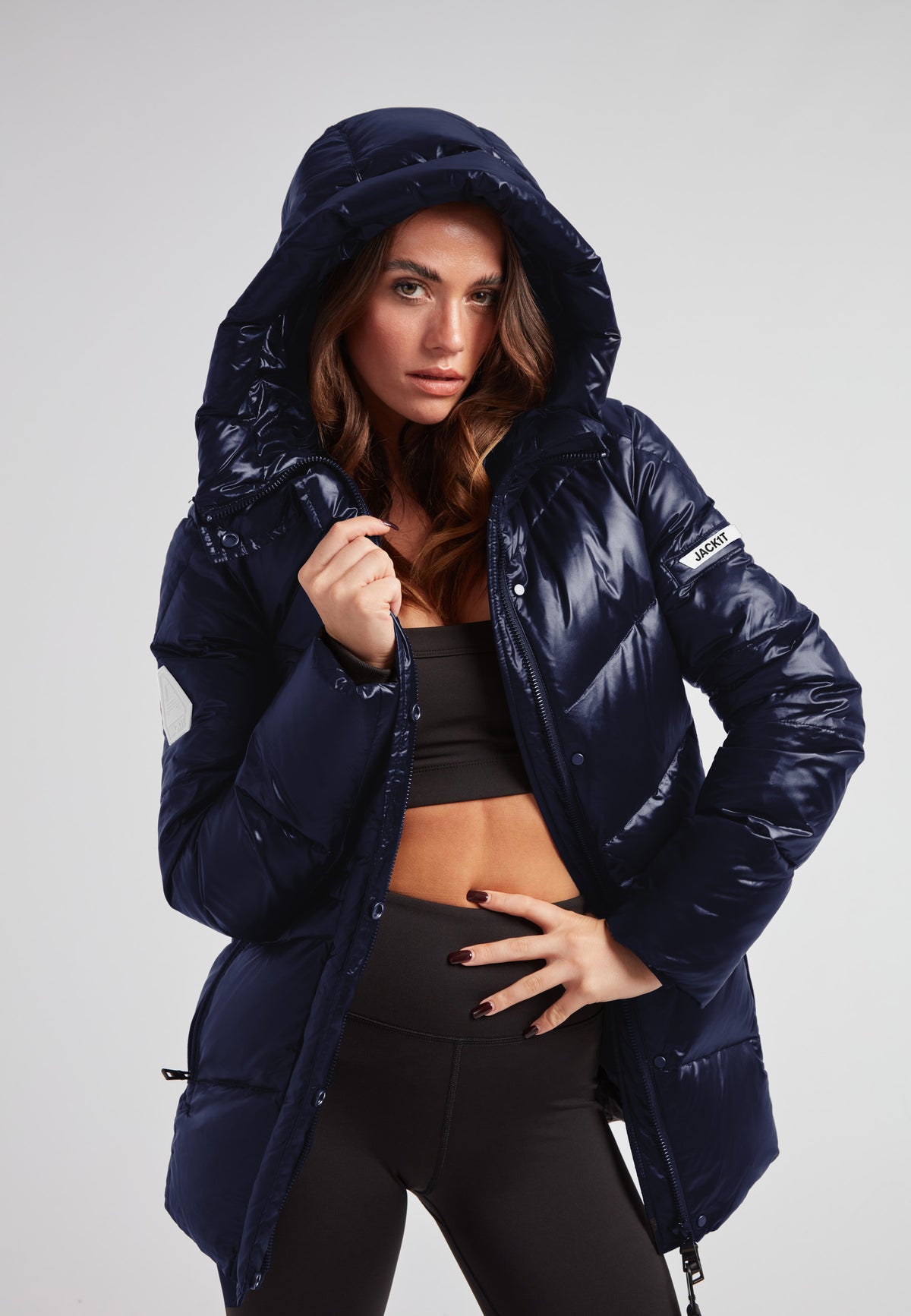 Womens navy down puffer coat with hood, featuring a mid-length silhouette and water repellent shell.