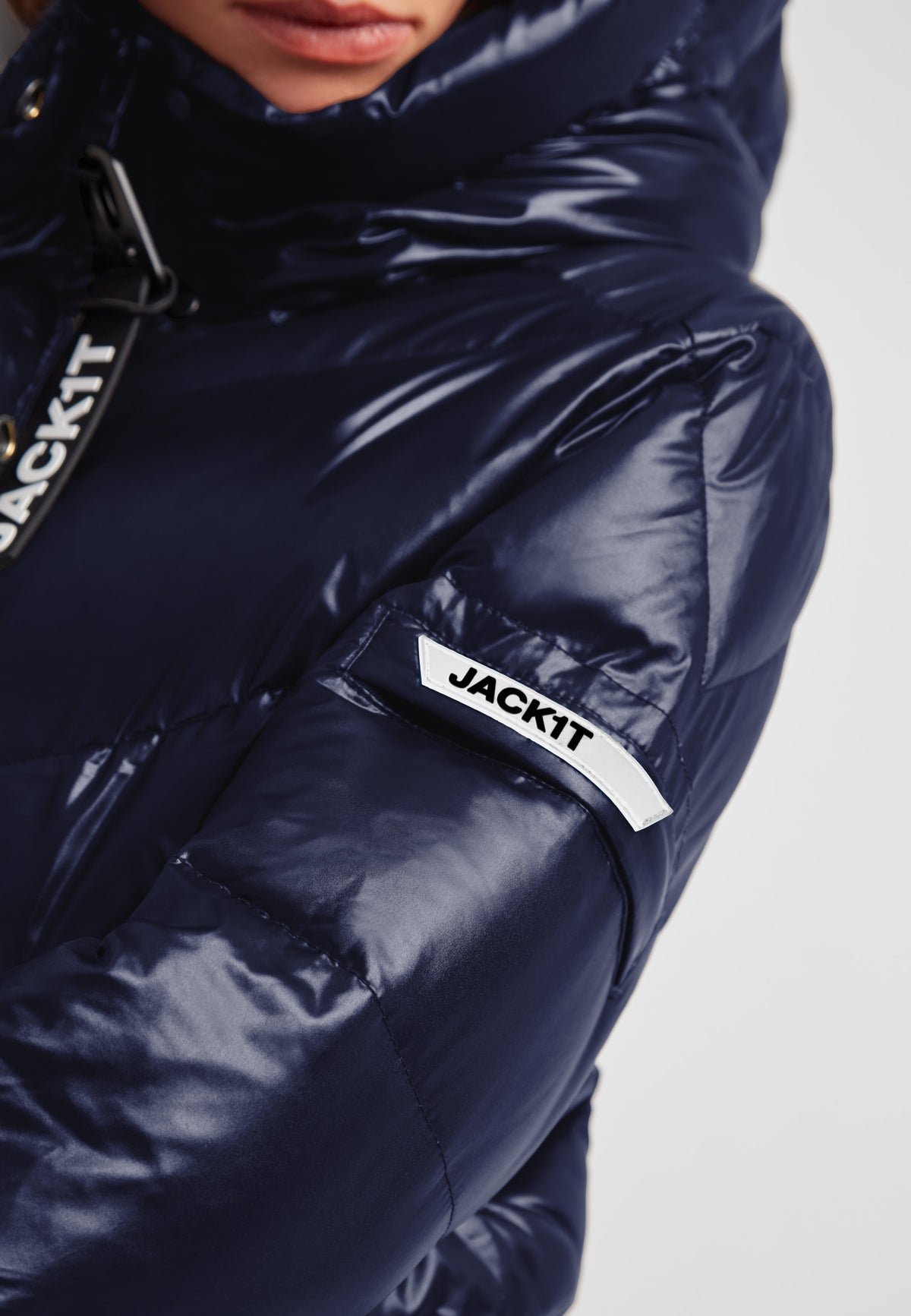 Close-up of the EZ Frontier Prime women's navy down puffer coat featuring a shiny finish and logo on the sleeve.